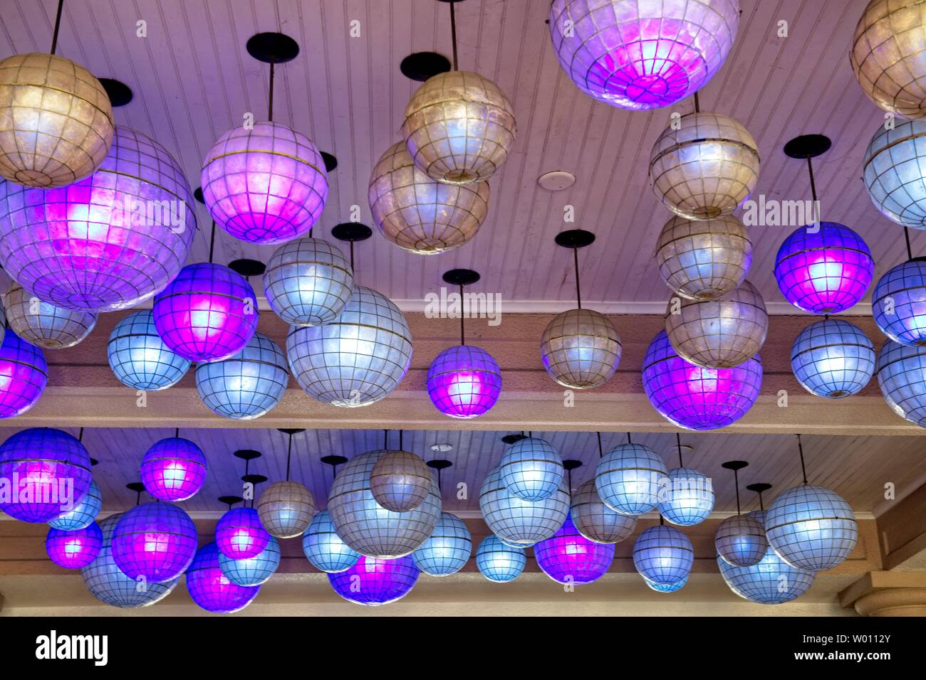 Mirrored balls hang from the ceiling as light fixtures Stock Photo