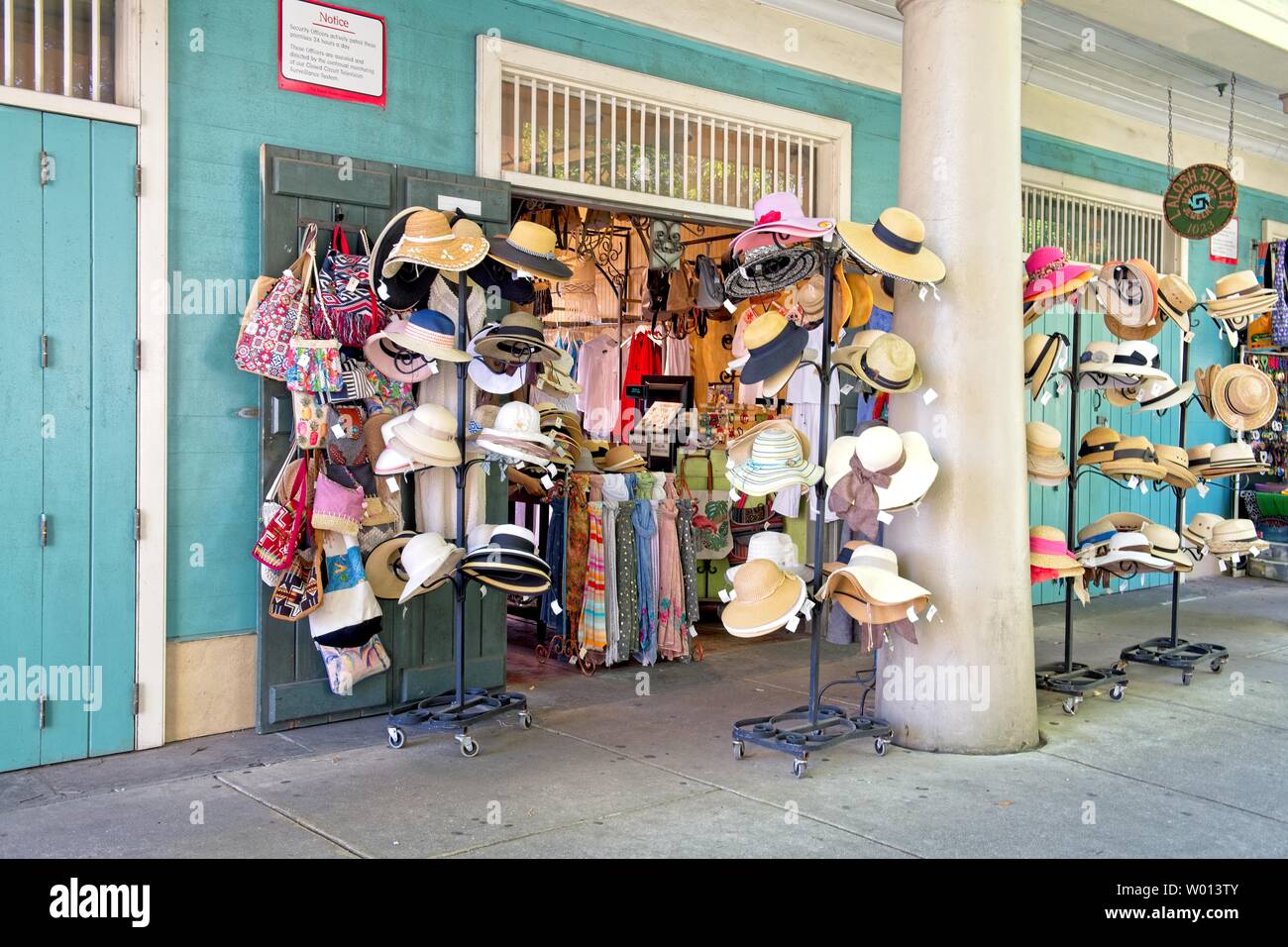 Racks of hats hang on stands outside a clothing store Stock Photo