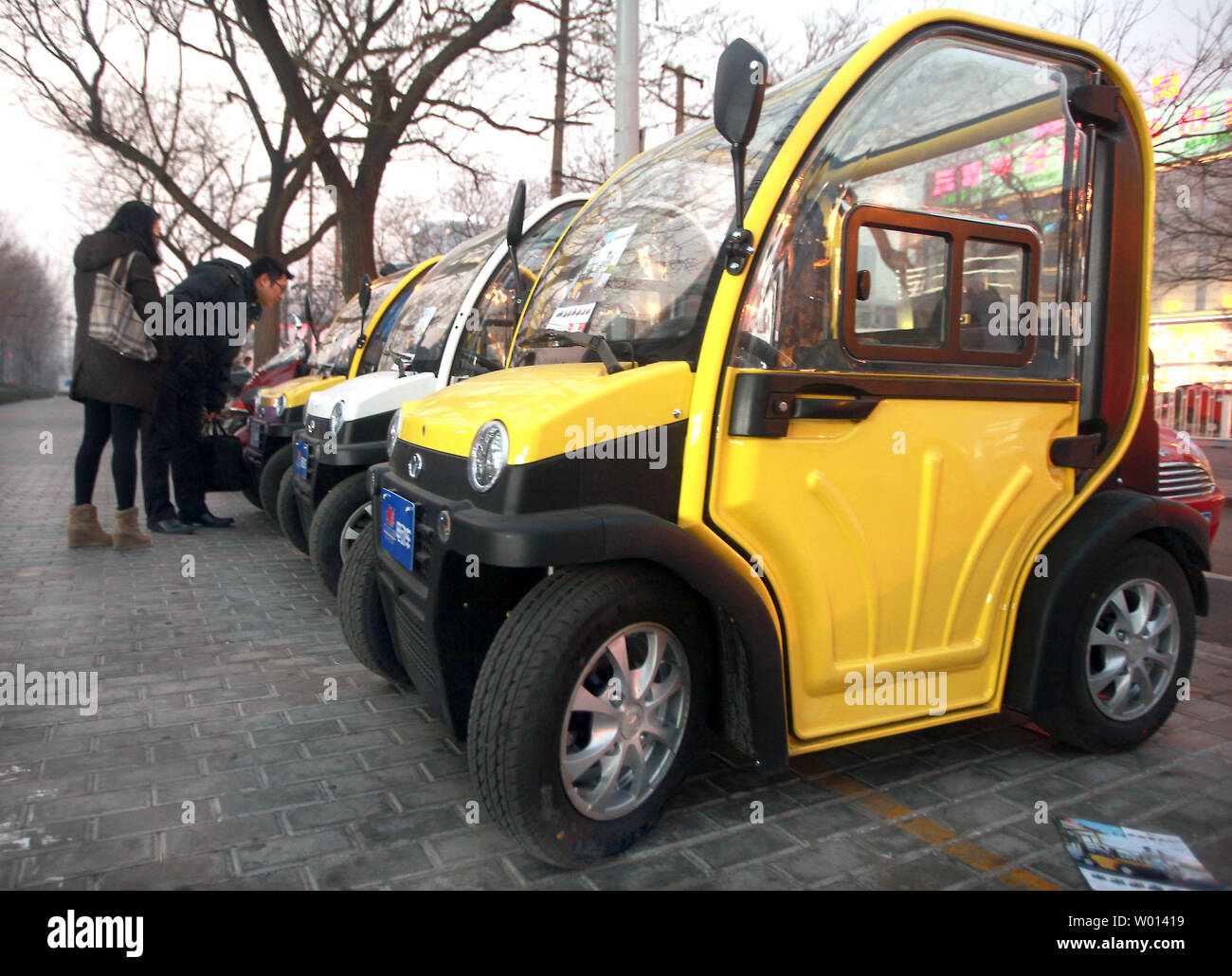 Small, electric cars, made in China, are displayed outside a showroom