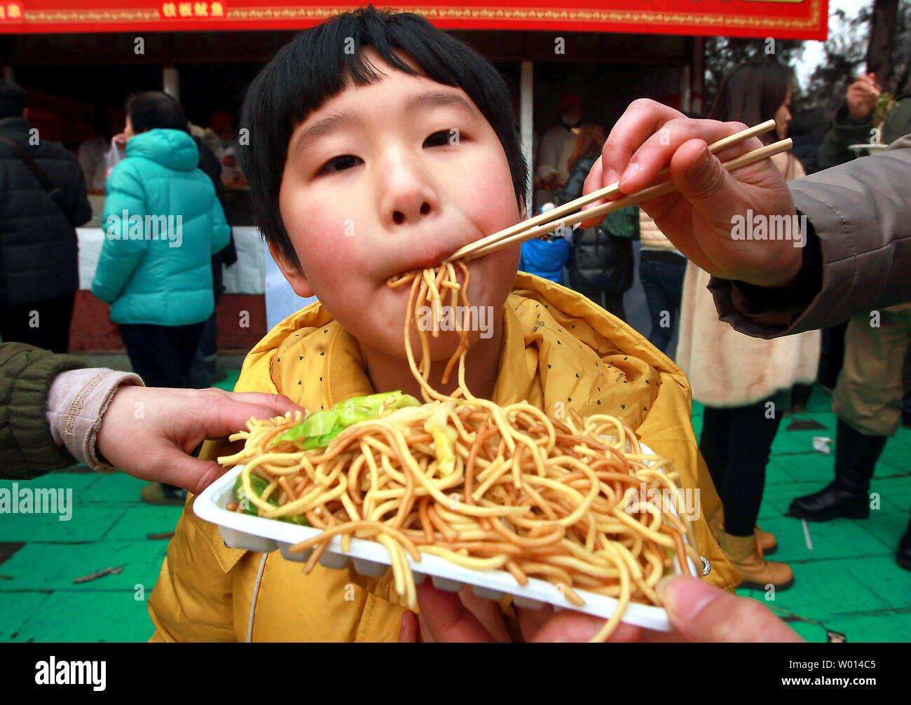 Chinese eat traditional street food at a Spring Festival temple fair celebrating China's Lunar New Year in Beijing on February 6, 2014. According to the Chinese lunar calendar, China welcomes the year Chinese eat traditional street food at a Spring Festival temple fair celebrating China's Lunar New Year in Beijing on February 6, 2014. According to the Chinese lunar calendar, China welcomes the year