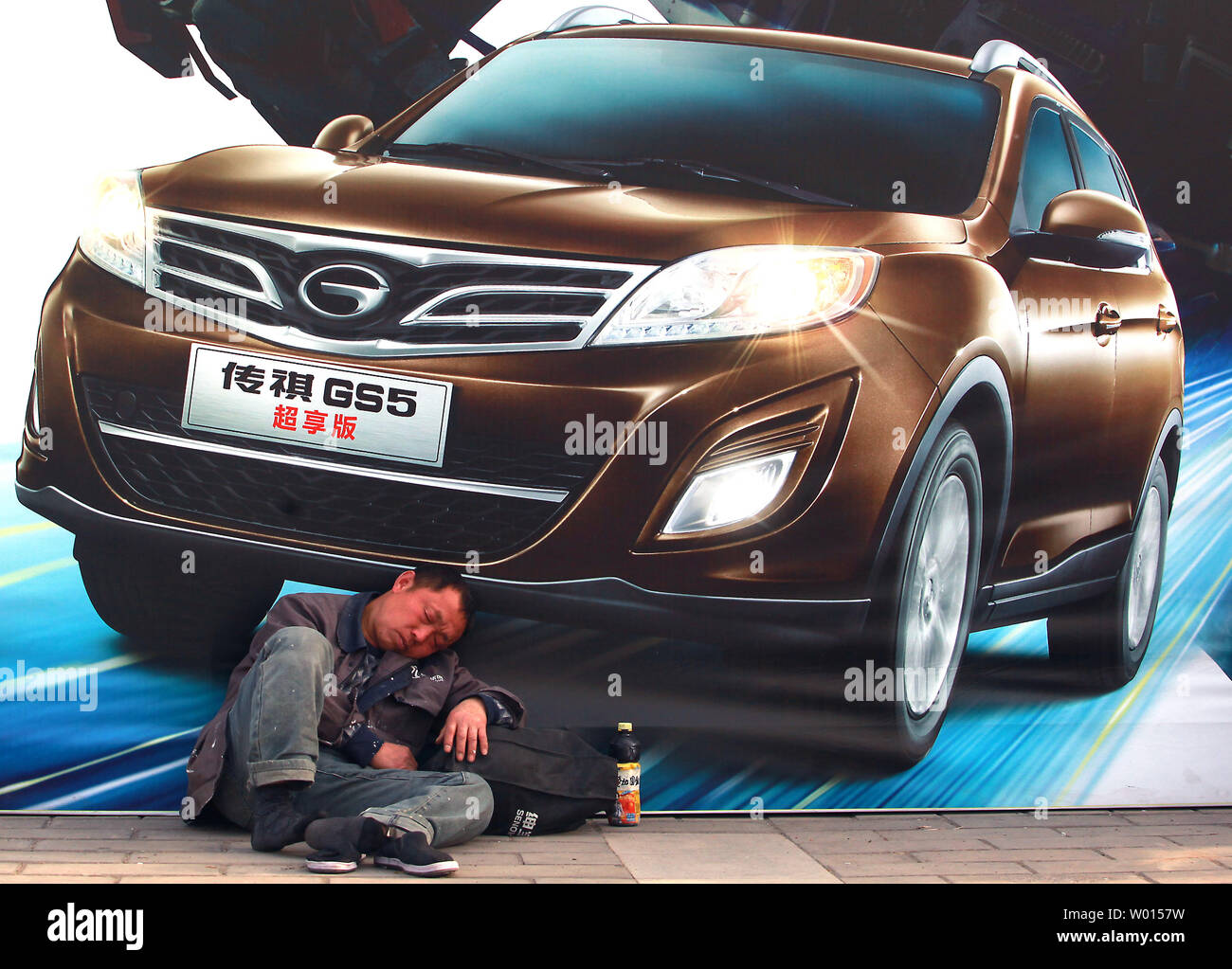 A Chinese man sleeps at Auto China 2014, billed as one of the largest auto  shows in the world, in Beijing on April 20, 2014. Strong demand for new  luxury cars throughout