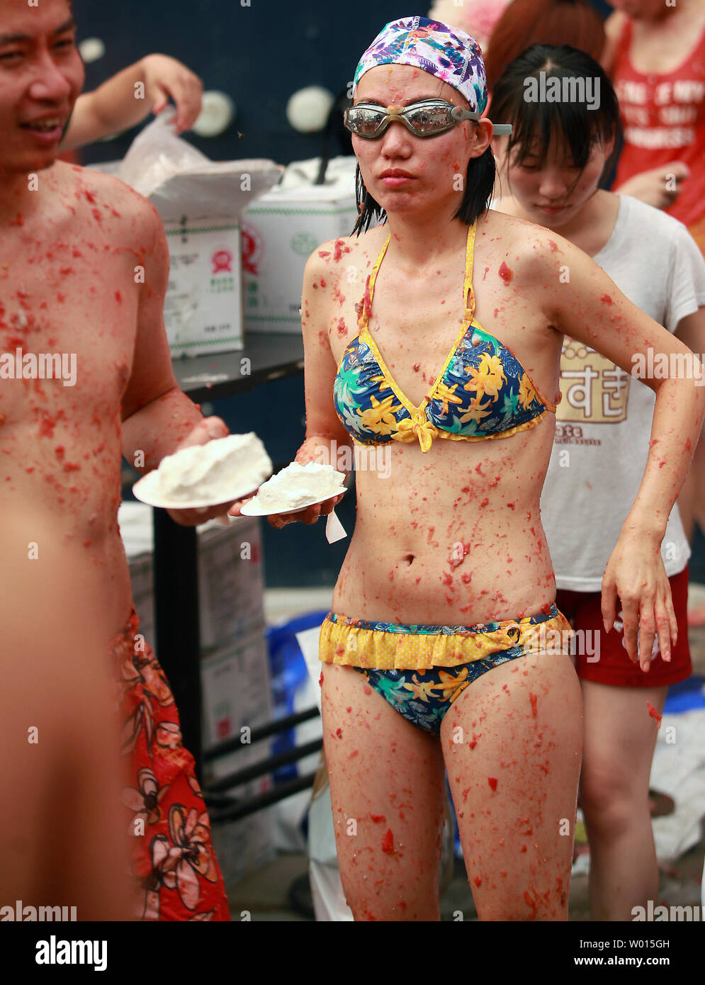 Chinese and foreigners take part in an annual tomato and food fight party  in Beijing on July 6, 2014. A few hundred tomato-slinging party-goers took  part in what organizers called a mini