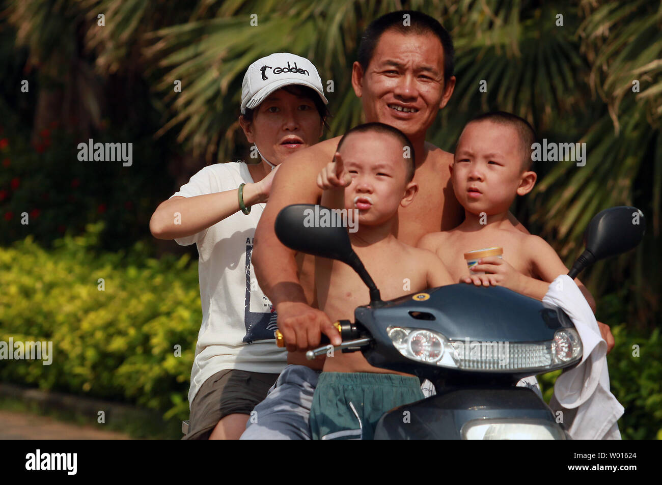 A Chinese family rides past a scenic lake in Beijing on September 14, 2014.  With more than 1.3 billion people, China is the world's most populous country.  China's total population of 1.3 billion continues to grow, but the nation's working-age population - those between 16 and 59 - has dropped two years in a row, raising concerns about a shrinking labor force and its economic consequences.     UPI/Stephen Shaver Stock Photo