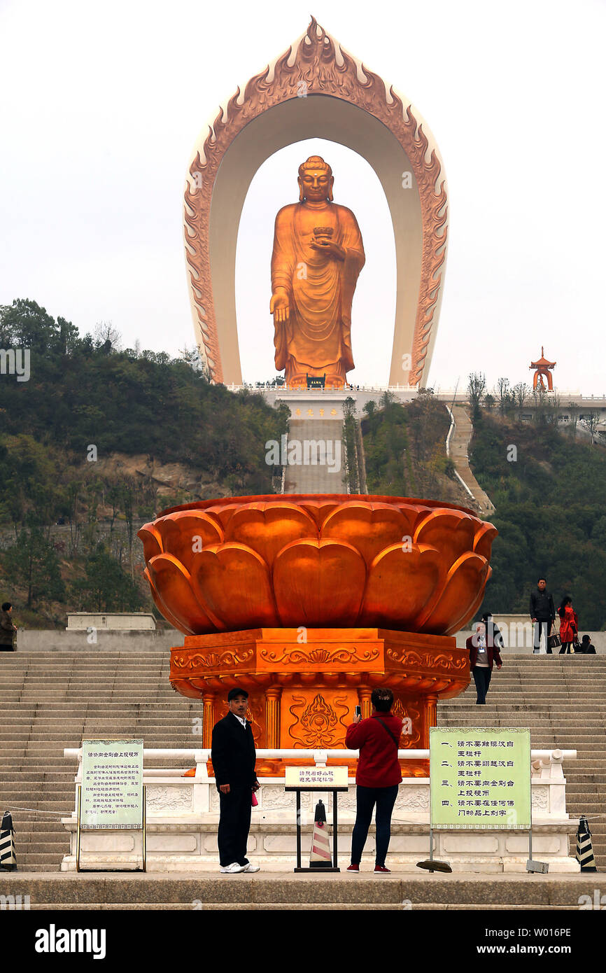 Chinese tourists visit the Donglin Buddha, located in the foothills of Lushan Mountain in east China's Jiangxi Province, on November 19, 2014.  The Buddha statue is  the world's highest Amitabha statue, according to the government.  China has slowly, but positively embraced ecotourism as unchecked development across the country has begun threatening cultural heritage areas and the traditional ways of life in ethnic-rich provinces.     UPI/Stephen Shaver Stock Photo