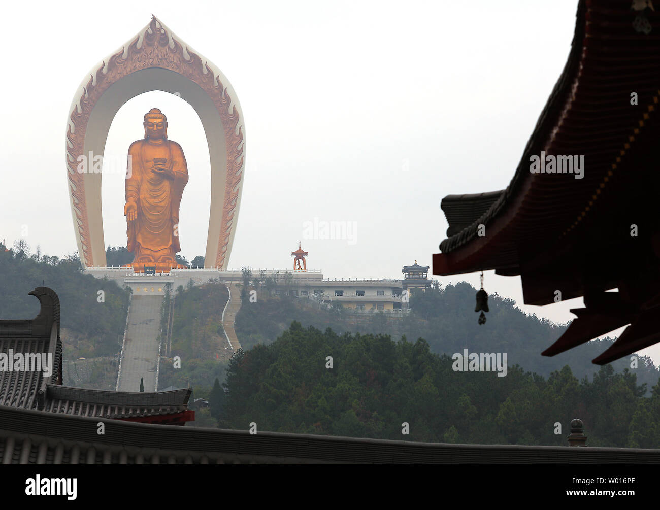 Chinese tourists visit the Donglin Buddha, located in the foothills of Lushan Mountain in east China's Jiangxi Province, on November 19, 2014.  The Buddha statue is  the world's highest Amitabha statue, according to the government.  China has slowly, but positively embraced ecotourism as unchecked development across the country has begun threatening cultural heritage areas and the traditional ways of life in ethnic-rich provinces.     UPI/Stephen Shaver Stock Photo