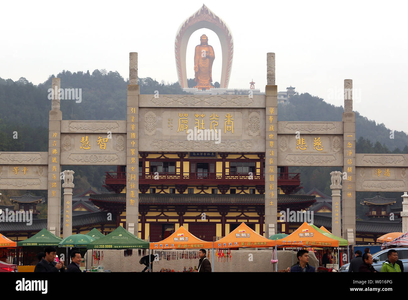 Chinese tourists visit the Donglin Buddha, located in the foothills of Lushan Mountain in east China's Jiangxi Province, on November 19, 2014.  The Buddha statue is  the world's highest Amitabha statue, according to the government.  China has slowly, but positively embraced ecotourism as unchecked development across the country has begun threatening cultural heritage areas and the traditional ways of life in ethnic-rich provinces.     UPI/Stephen Shaver Stock Photo