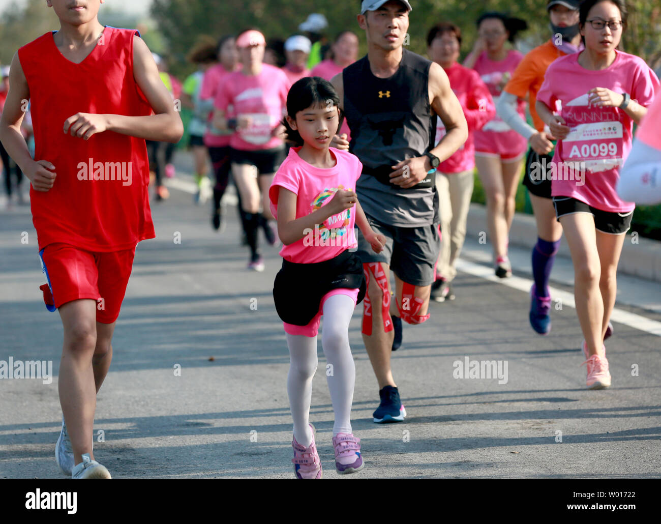 A girl runs hard in a 5-kilometer marathon. Stock Photo