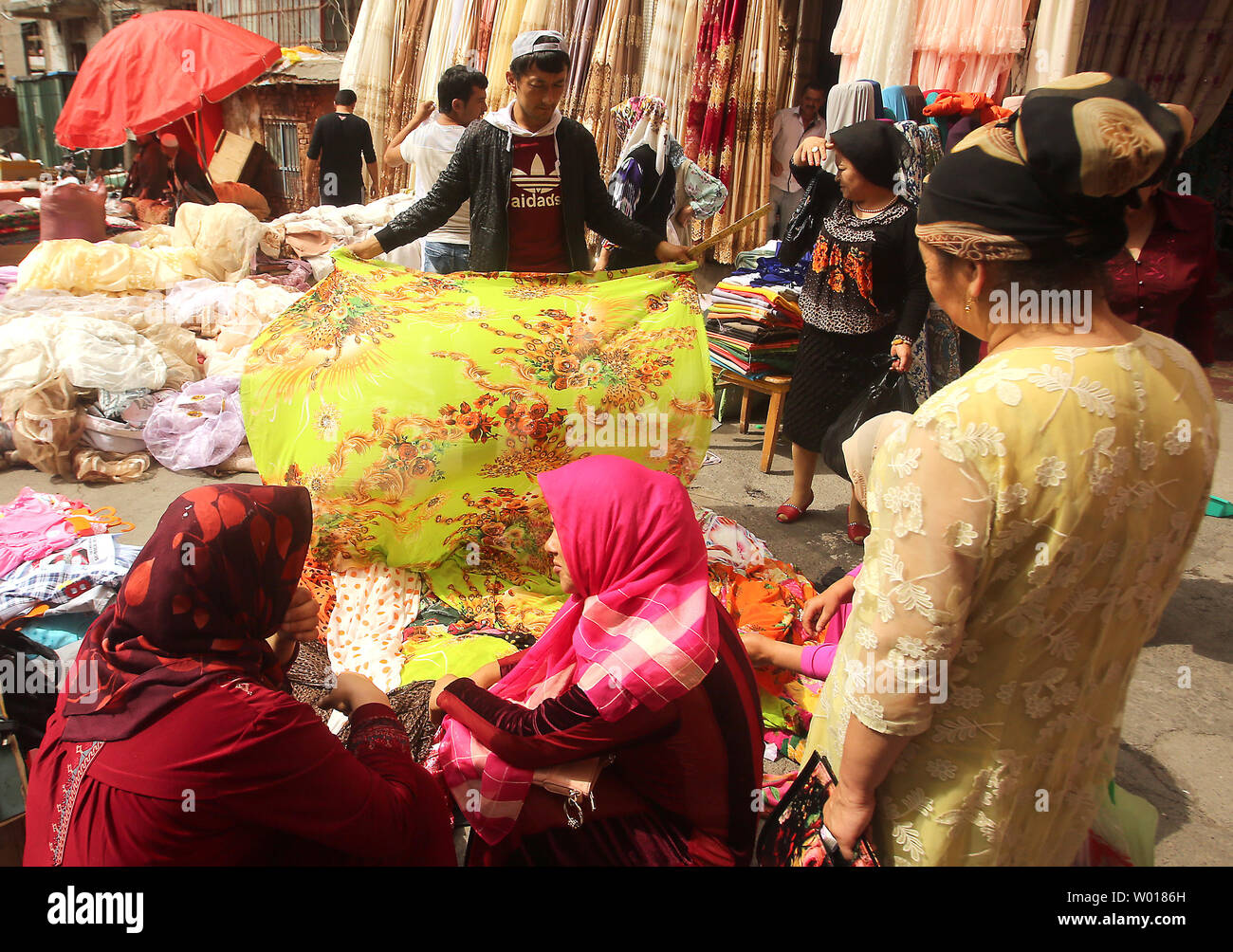 Muslim Uygurs and Kazakhs shop at a fabric market during Ramadan in what many consider the Muslim capital of China, Urumqi, the capital of China's predominantly Muslim and restive Xinjiang Province, on June 29, 2015.  Urumqi has been the sight of several bloody riots between the Chinese Han and the Muslim Uygurs, prompting government officials to restrict movements and communications within the city, as well as travel outside the province.       Photo by Stephen Shaver/UPI Stock Photo
