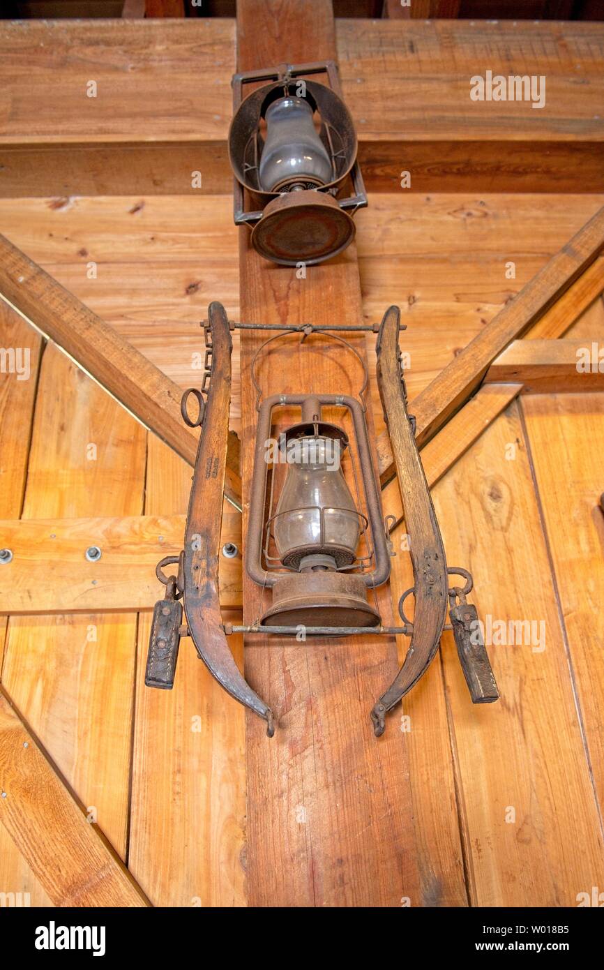 A rusty antique lantern hangs from a farmhouse wall Stock Photo