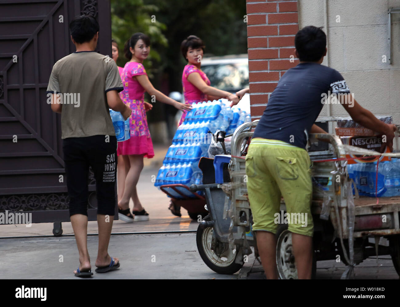 North Korean women pickup a delivery of beverages from Chinese men at their embassy in Beijing on August 26, 2015.  Despite China being North Korea's lifeline regarding energy, food and international diplomacy, North Korean leader Kim Jong Un declined an invitation to a attend a military parade commemorating China's victory over Japan during World War II.  The snub was announced amid escalating military tensions between North and South Korea.    Photo by Stephen Shaver/UPI Stock Photo