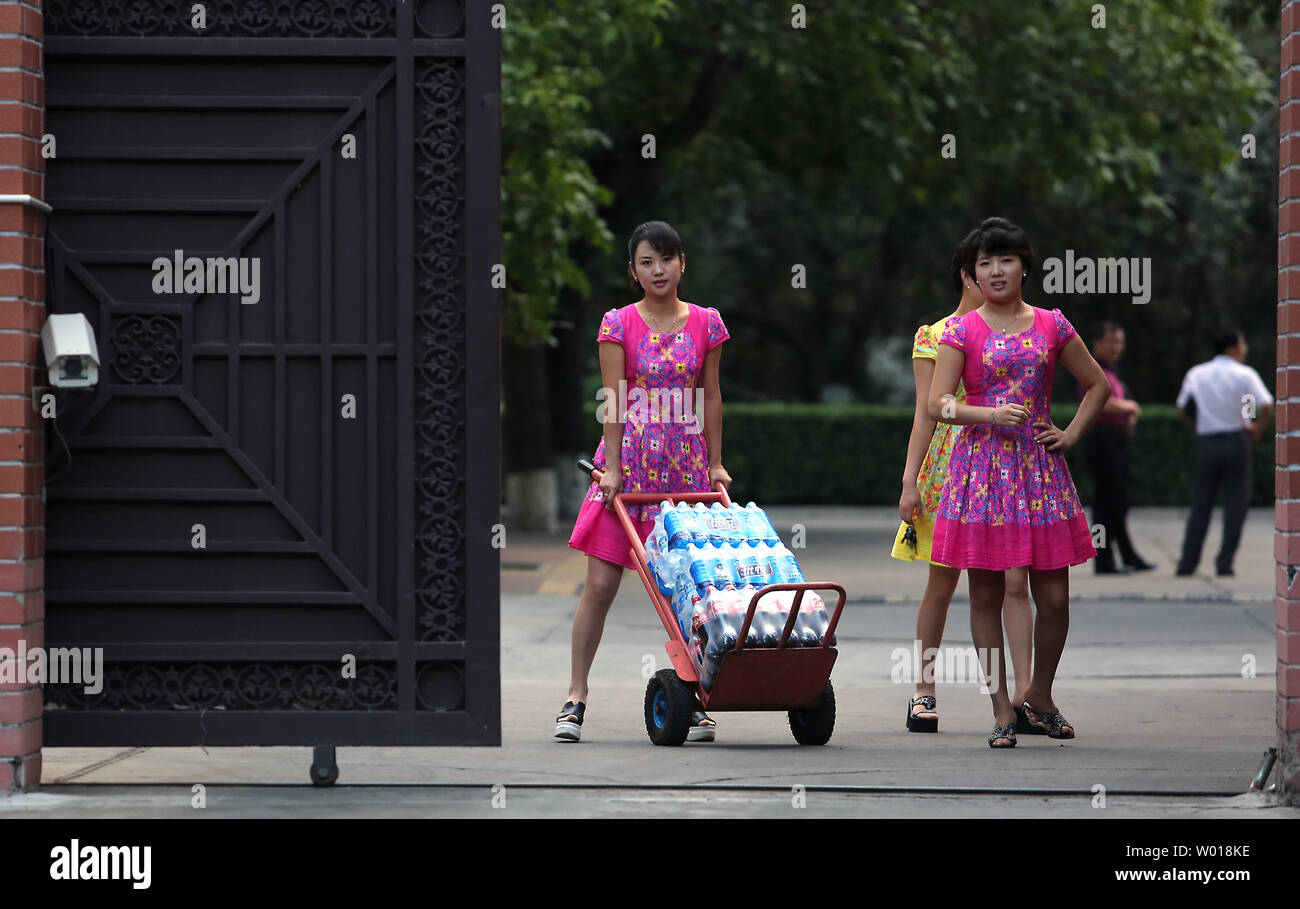 North Korean women pickup a delivery of beverages from Chinese men at their embassy in Beijing on August 26, 2015.  Despite China being North Korea's lifeline regarding energy, food and international diplomacy, North Korean leader Kim Jong Un declined an invitation to a attend a military parade commemorating China's victory over Japan during World War II.  The snub was announced amid escalating military tensions between North and South Korea.    Photo by Stephen Shaver/UPI Stock Photo