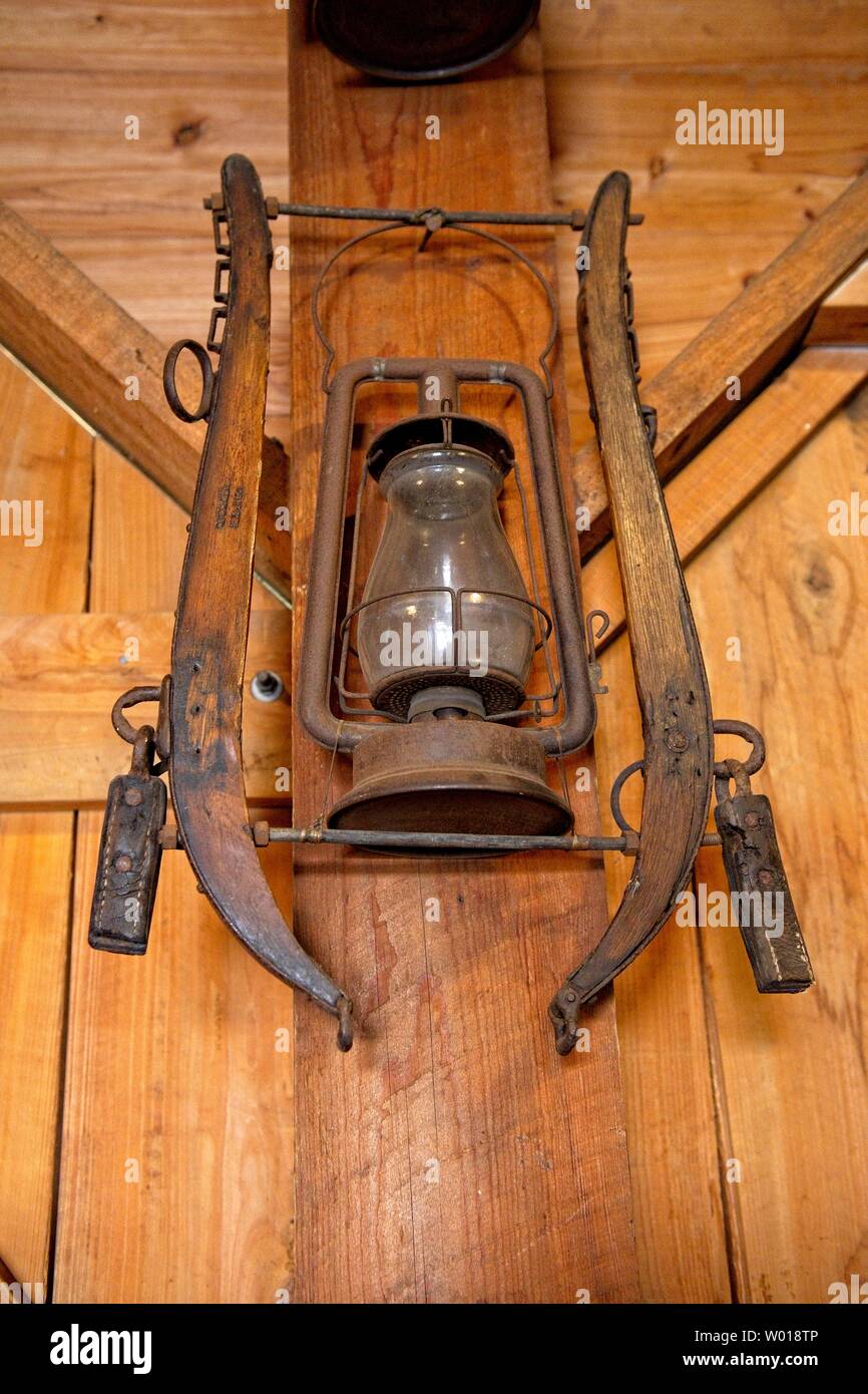 A rusty antique lantern hangs from a farmhouse wall Stock Photo