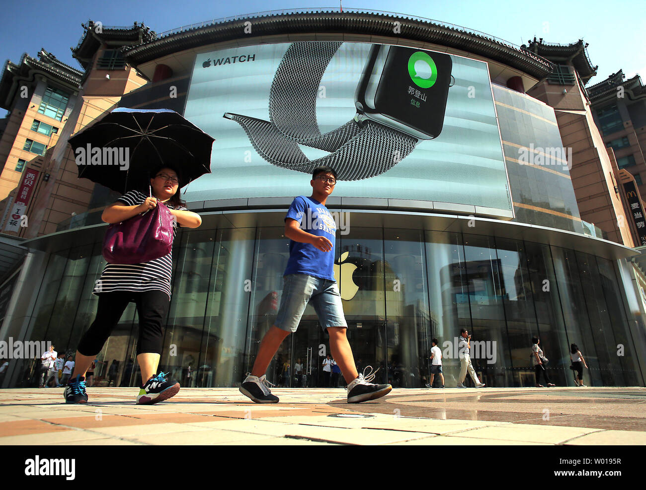 Chinese walk past one of Apple's main showrooms in Beijing on September 14, 2015.  With Apple shares plunging on concerns that its strong growth in China will suffer from a slowing economy, Chief Executive Tim Cook took the unusual step of reassuring jittery shareholders that its business in China is doing just fine.     Photo by Stephen Shaver/UPI Stock Photo
