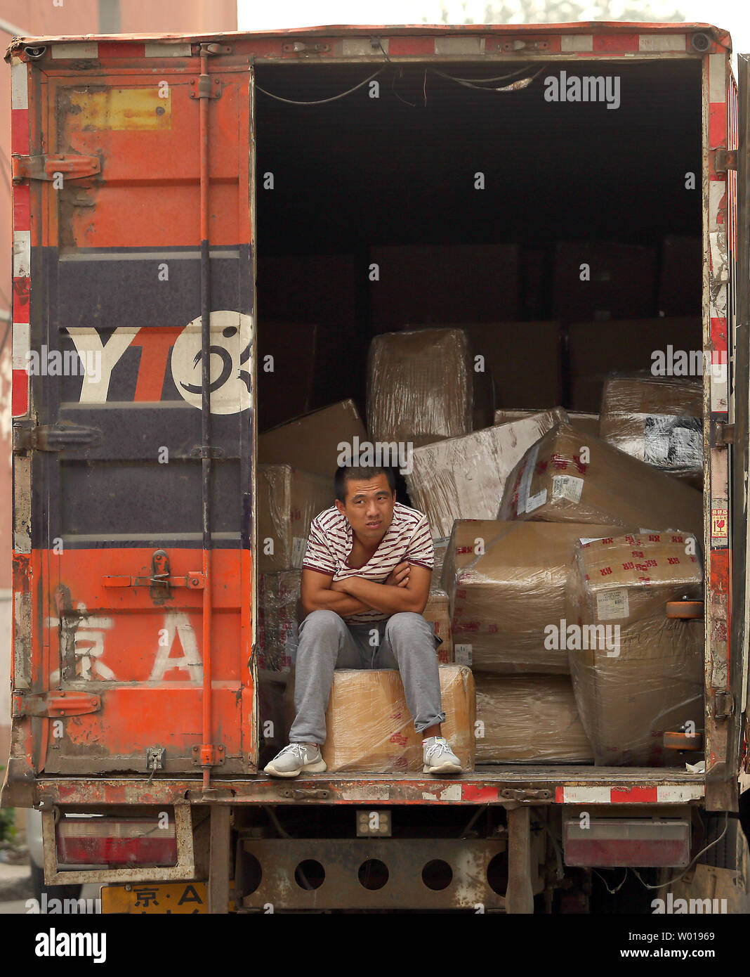A Chinese worker sits in the back of delivery truck in Beijing on September 23, 2015.  International stock market turmoil and a surprise Chinese currency devaluation has fueled fears of a Chinese economic slump with global repercussions.    Photo by Stephen Shaver/UPI Stock Photo
