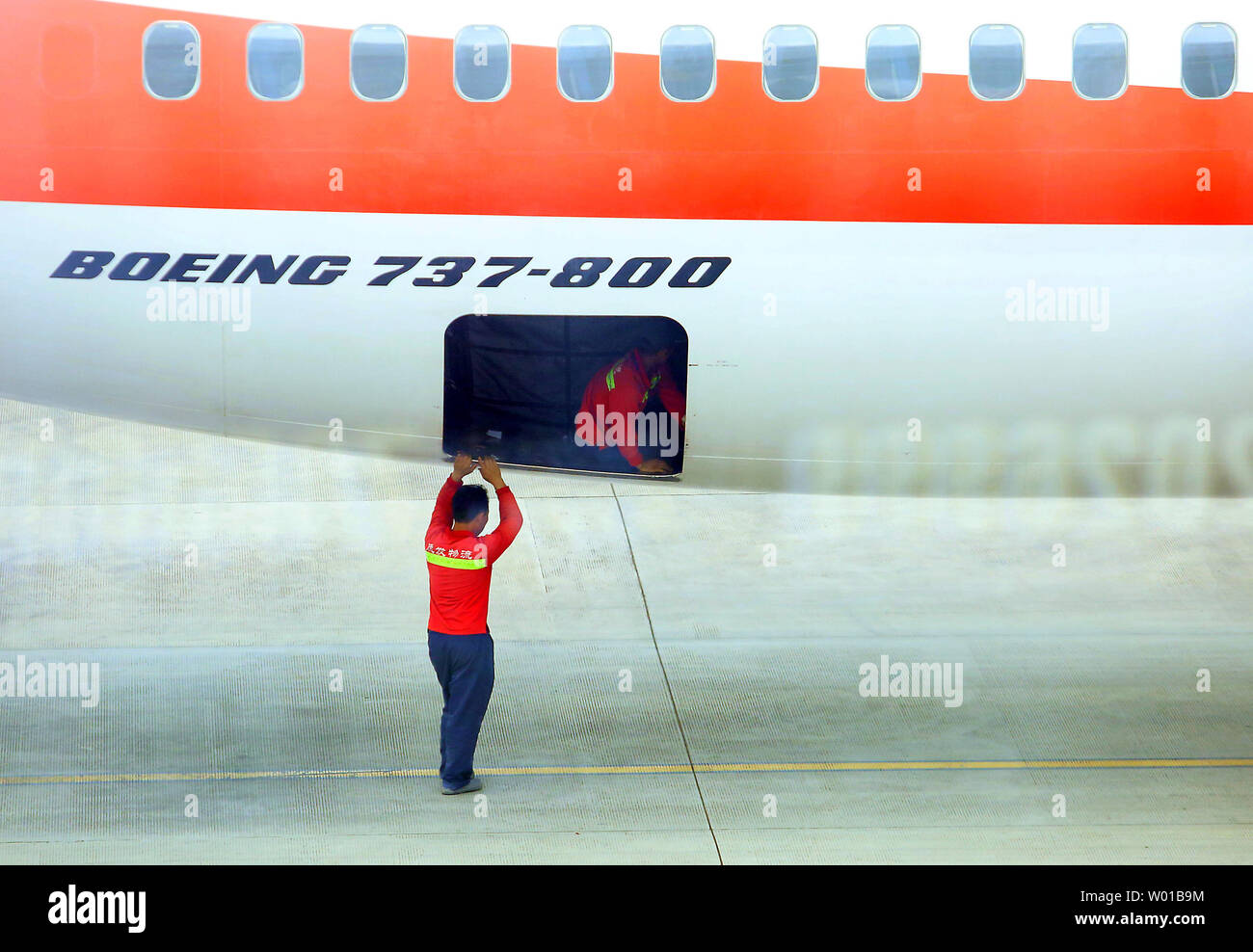 Chinese cargo handlers finish loading a Boeing 737-800 owned by a ...