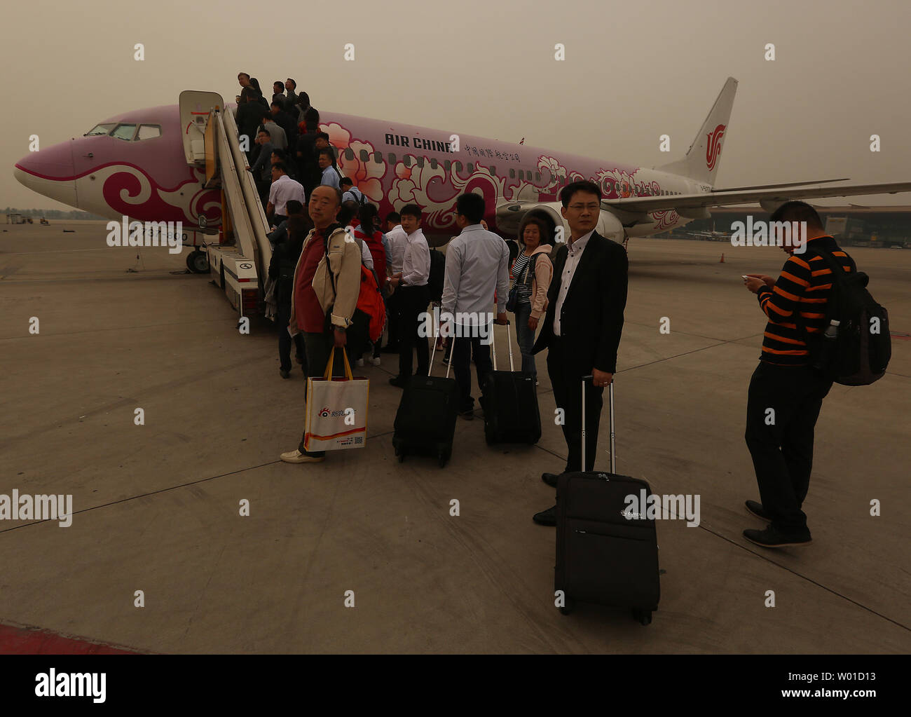 Passengers board an Air China jet at Beijing's international airport as hazardous weather hits the capital on May 3, 2017.  A major dust storm is choking a large portion of northern China, in yet another air quality crisis to affect the country.  Dozens of flights were delayed a cancelled due to the weather.      Photo by Stephen Shaver/UPI Stock Photo