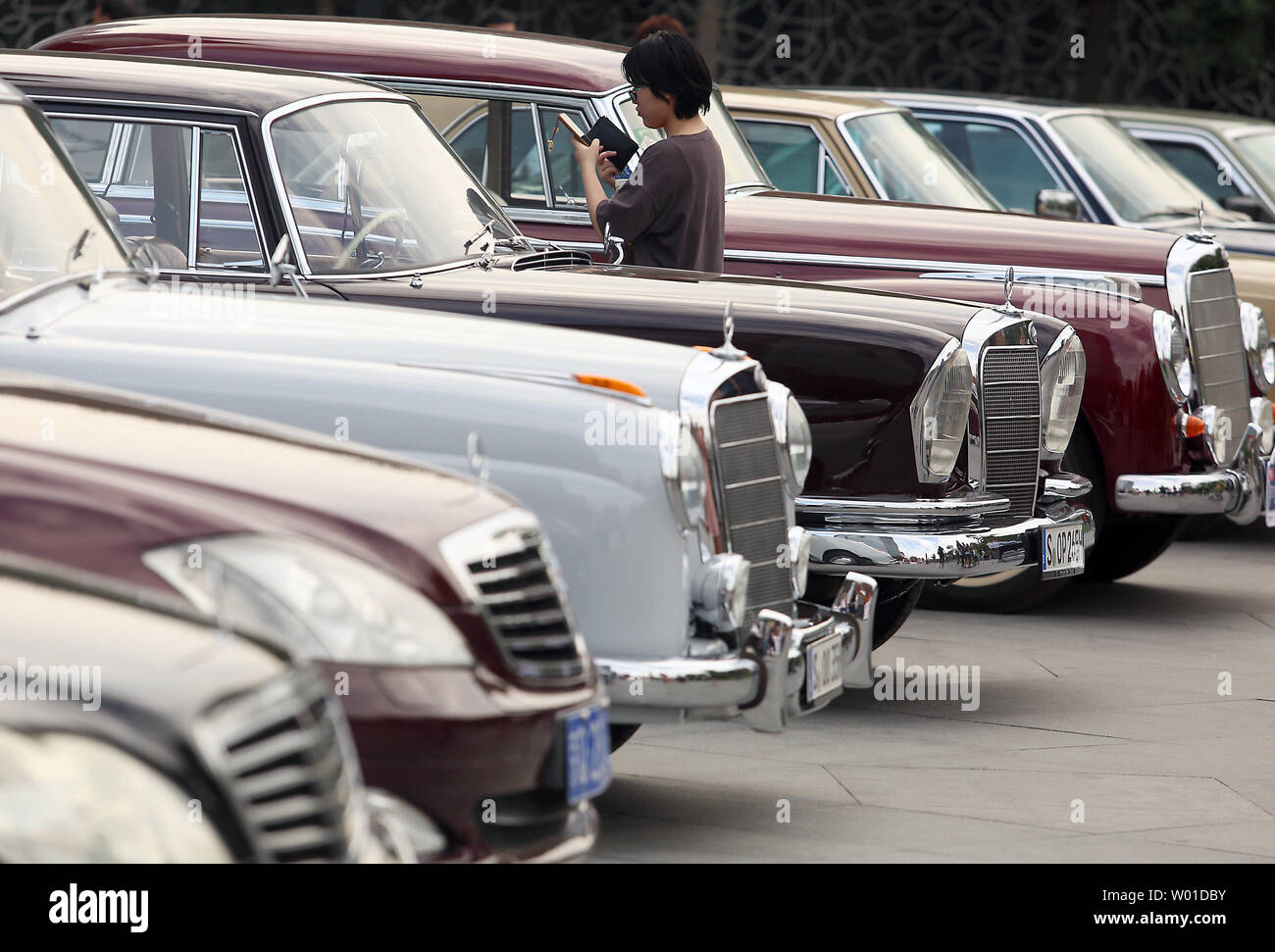 A Chinese woman takes photos of vintage Mercedes-Benz cars on display in the lead-up to a classic car rally in Beijing on September 18, 2017.    Mercedes-Benz was one of the first major luxury cars allowed to be imported in to China, and still retains a major share of the luxury automobile market.  China has emerged as one of the world's top importers of luxury cars, and is the world's largest automobile market.   Photo by Stephen Shaver/UPI Stock Photo