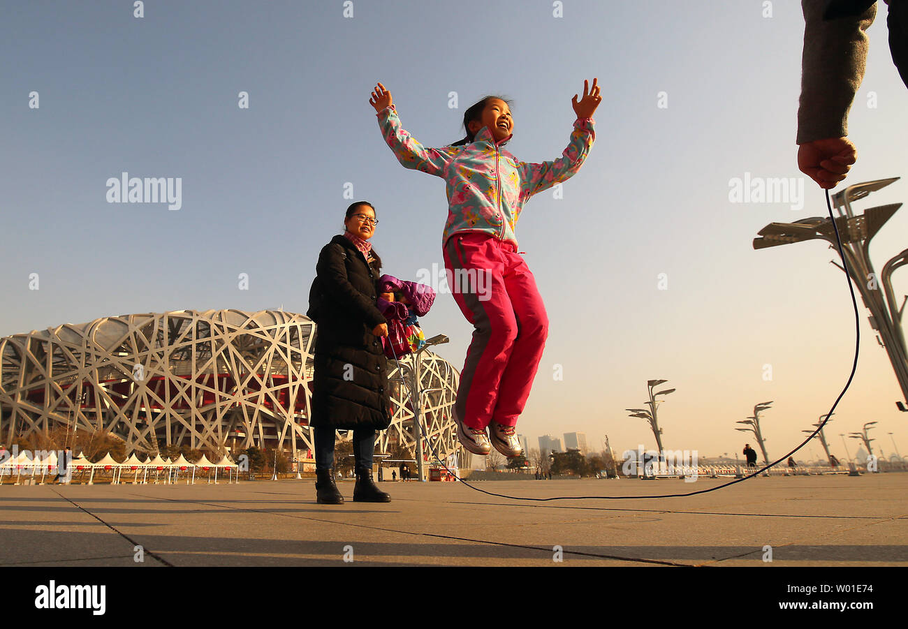A Chinese girl jump-ropes on the 2008 Olympic Green, with the iconic ...