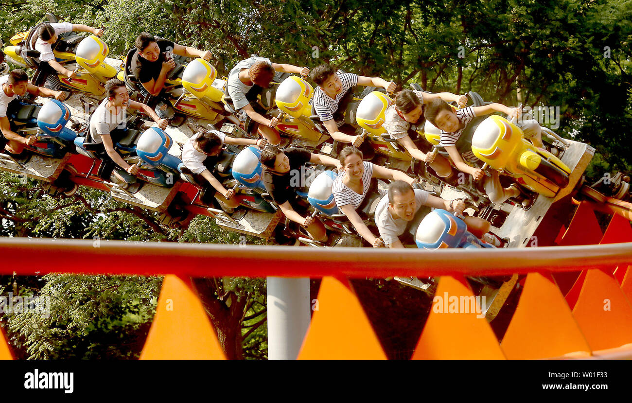 Chinese ride a new, modern roller coaster in a park in Beijing on June ...