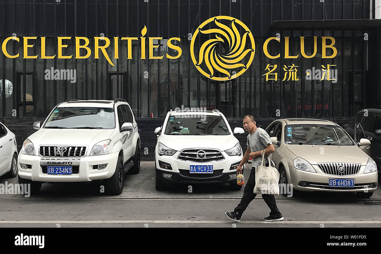Chinese Walk Past An Upscale Club Catering To Foreigners And Rich