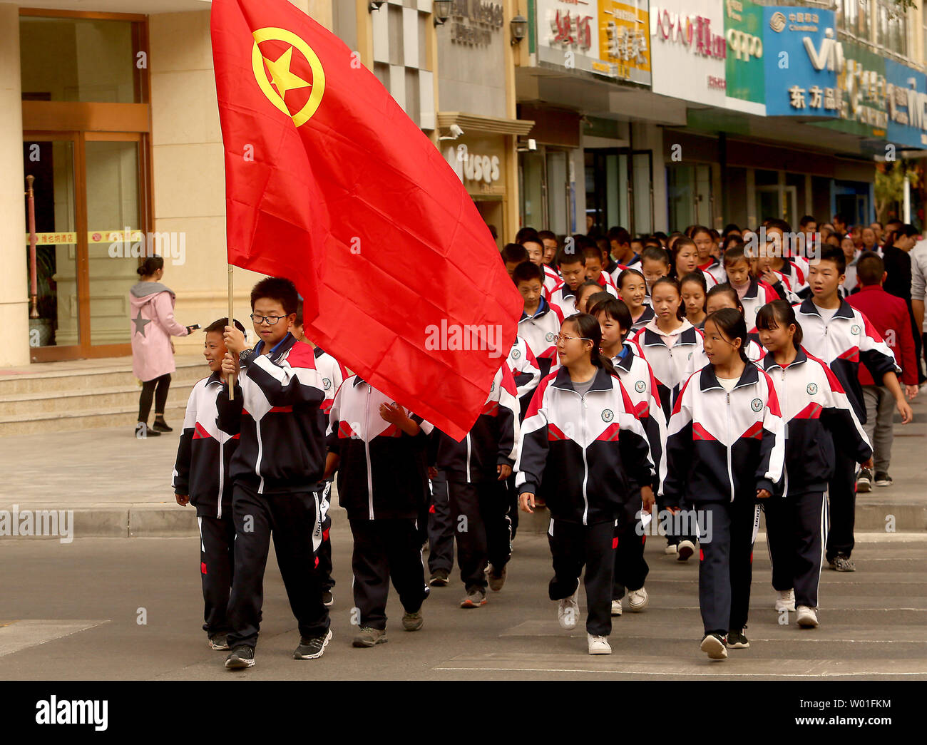 Young Patriots, linked closely with the Communist Party, march down a sidewalk in Dunhuang, Gansu Province, on September 30, 2018.  Public schools in China are highly influenced by Communist dogma and history, with students being taught and encouraged to embrace the principles of socialism.      Photo by Stephen Shaver/UPI Stock Photo