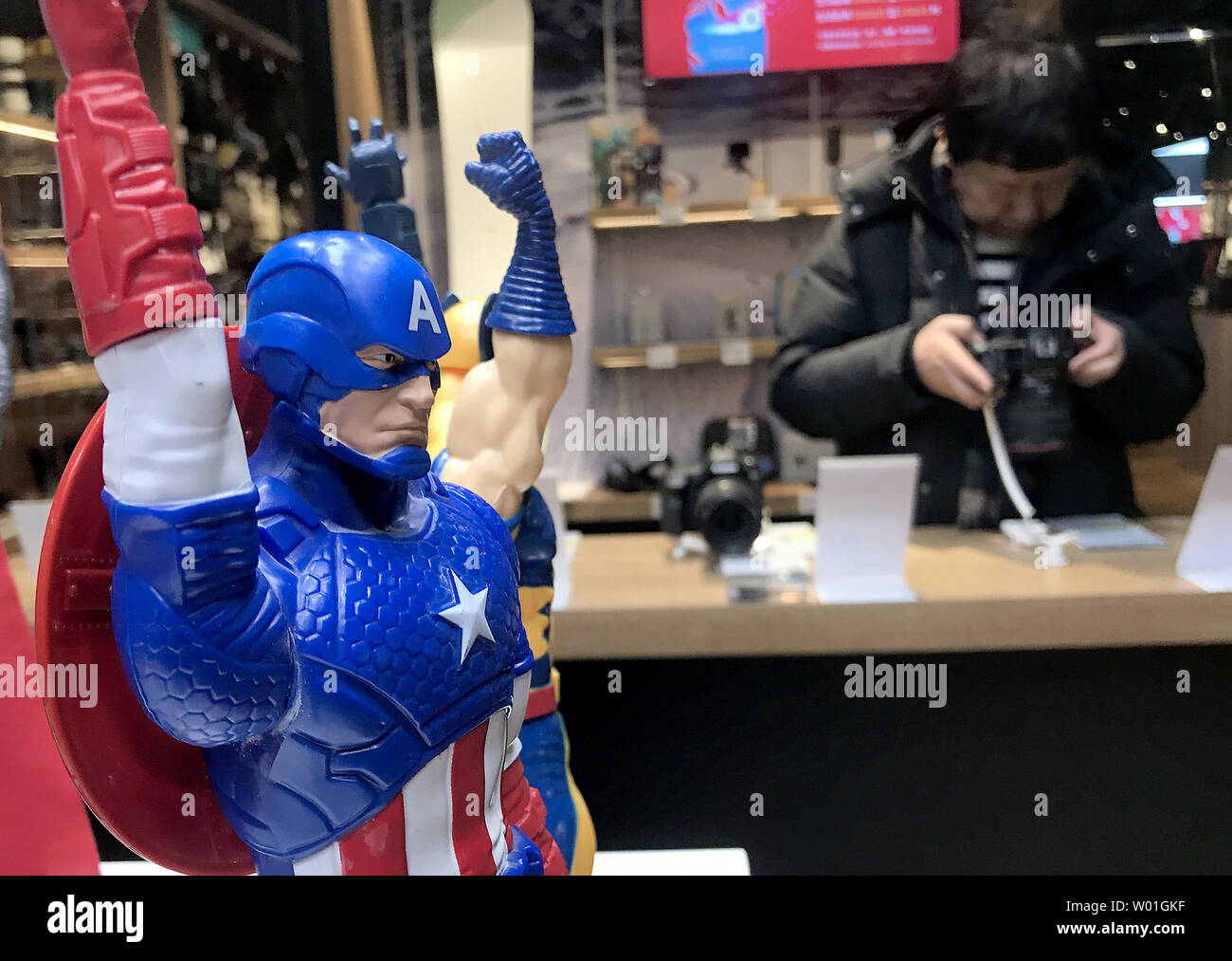 A Chinese man checks out cameras next to a U.S. action heroes display in an international shopping plaza in Beijing on January 30, 2019.  China and the U.S. cannot do without one another, one of Beijing's most senior officials said as the world's two biggest economies struggle to end a damaging trade war.    Photo by Stephen Shaver/UPI Stock Photo