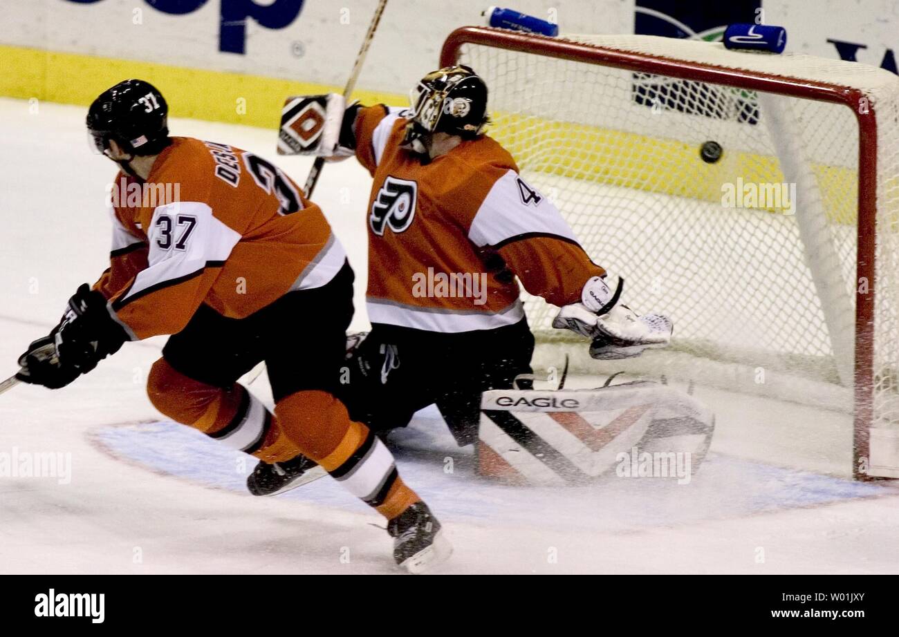 The Flyers' Chris Therien (6) and Eric Desjardins (37) swarm to