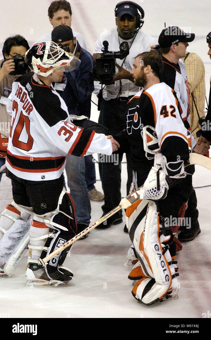 The Flyers' Jeremy Roenick (97) takes a shot on his recently healed jaw  from the Devils' Goaltender Martin Brodeur (30) as Philadelphia hosts New  Jersey in the first game of the Eastern