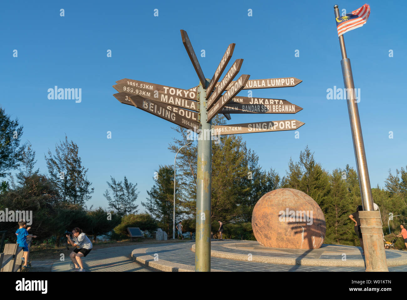 TIP OF BORNEO - BORNEO; MAY29 2019; Sign pioting to major world cities and paces and Malaysian flag at the tip of Borneo. Stock Photo