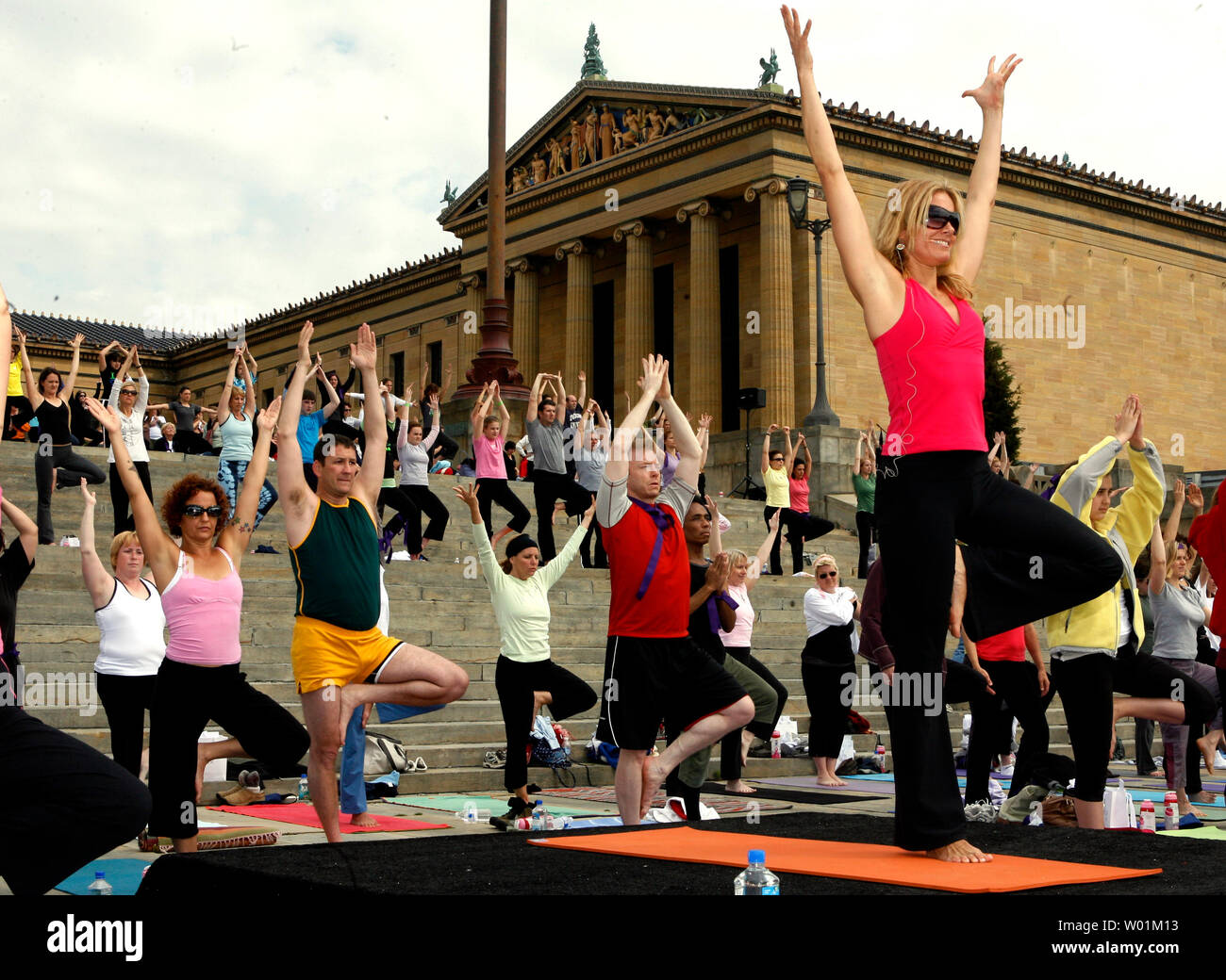 Jennifer Schelter (far right)  leads some 600 breast cancer survivors and their families through yoga exercises on the steps of the Philadelphia Art Museum in downtown Philadelphia May 20 2007. They participate in the the mass yoga class annually to raise funds and awareness of breast cancer  issues.  (UPI Photo/John Anderson) Stock Photo