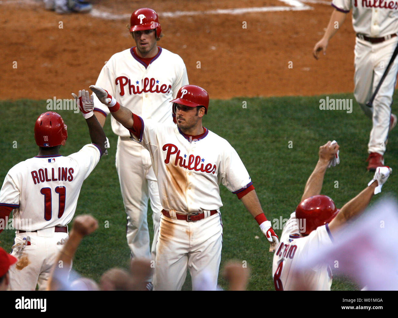 Philadelphia Phillies Jimmy Rollins (11) greets teammates Greg Dobbs and Jason Werth (background) at the dugout after they scored during 3nd inning Philadelphia Phillies-Los Angeles Dodgers NLCS play in Philadelphia at Citizens Bank Park October 10, 2008. Phillies Shane Victorino (far R) raises his arms in jubliation.      (UPI Photo/John Anderson) Stock Photo