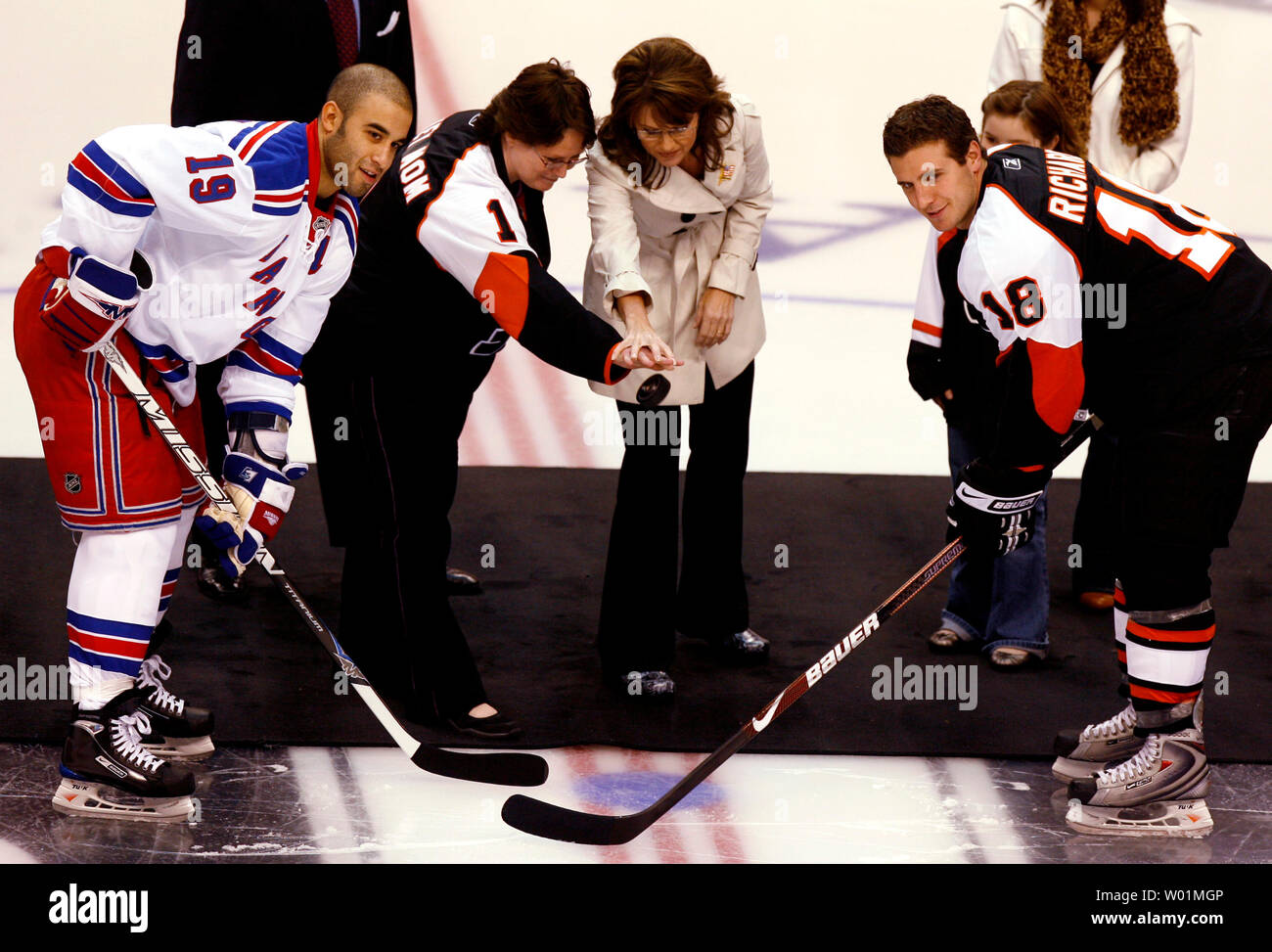 Republican Vice-Presidential candidate Alaska Gov. Sarah Palin drops the official puck before the Philadelphia Flyers home openening game in Philadelphia at the Wachovia Center on October 11, 2008. Helping her is Cathy O'Connell of Erderheim, Pa., selected by the Flyers as their #1 Hockey Mom of the Year. New York Rangers Scott Gomez (19) and Philadelphia Flyers Mike Richards (18).  (UPI Photo/John Anderson) Philadelphia Stock Photo