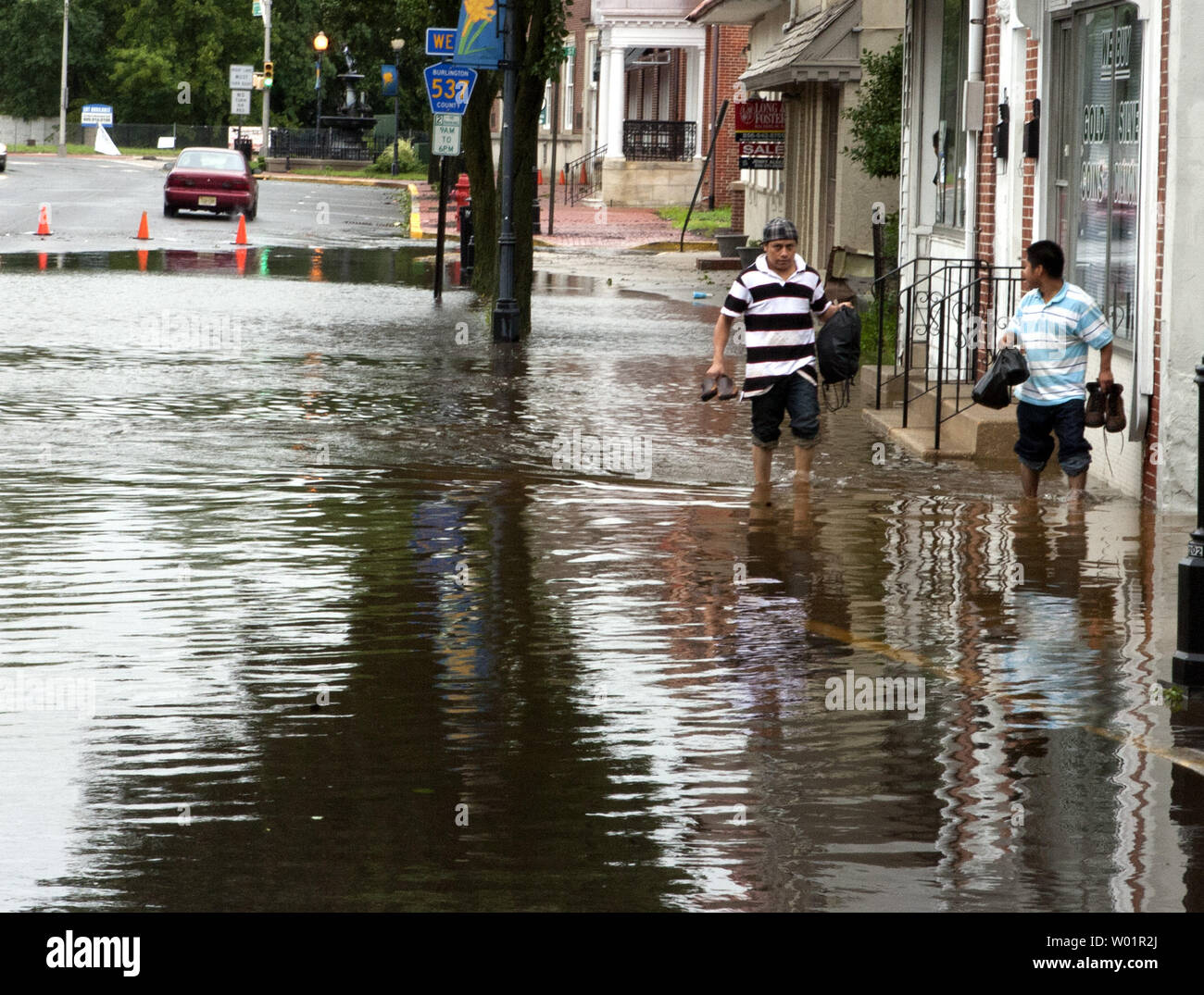 Two residents of Mt. Holly, New Jersey hold their shoes as they make their way along a flooded street from the intense rain produced by Hurricane Irene August 28, 2011. Some 800,000 people were evacuated from the Jersey Shore because of the Category One storm.    UPI/John Anderson Stock Photo