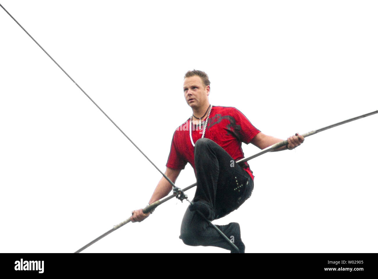 Nik Wallenda pauses to rest during his walk on a high wire that's over 1000 feet long and 200 above the  Allegheny River and Roberto Clemente Bridge without his shoes as part of the Three Rivers Regatta   in Pittsburgh on July 3,  2009. Wallenda is the seventh generation of the legendary Great Wallendas, who have performed in circus acts since the 1800s.      (UPI Photo/Archie Carpenter) Stock Photo