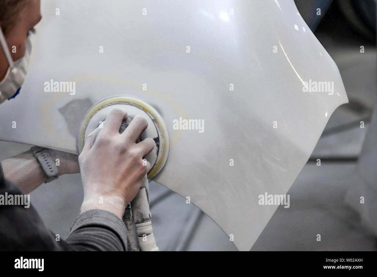 Preparation for painting a car element using sander and putty by a