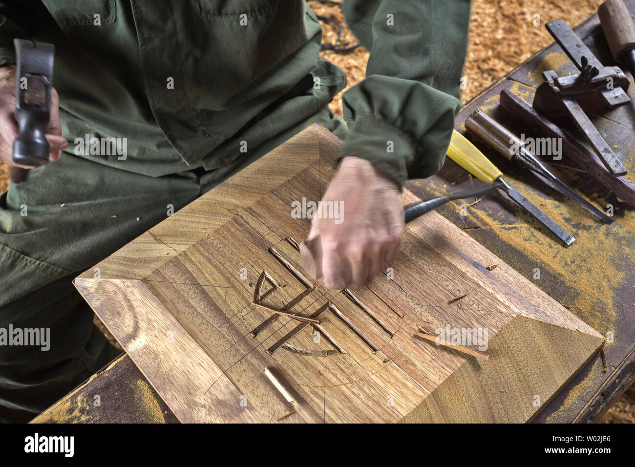 wood chisel carpenter tool hammer in hand working wooden background ...