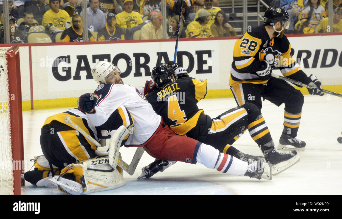 Pittsburgh Penguins defenseman Justin Schultz (4) and Columbus Blue Jackets left wing Nick Foligno (71) fall into Penguins goalie Marc-Andre Fleury (29) as  Penguins defenseman Ian Cole (28) clears the puck away from the goal during the third period of the Penguins 3-1 win of game one of the NHL Eastern Conference Playoff series at PPG Paints Arena  in Pittsburgh on April 12, 2017.   Photo by Archie Carpenter/UPI Stock Photo