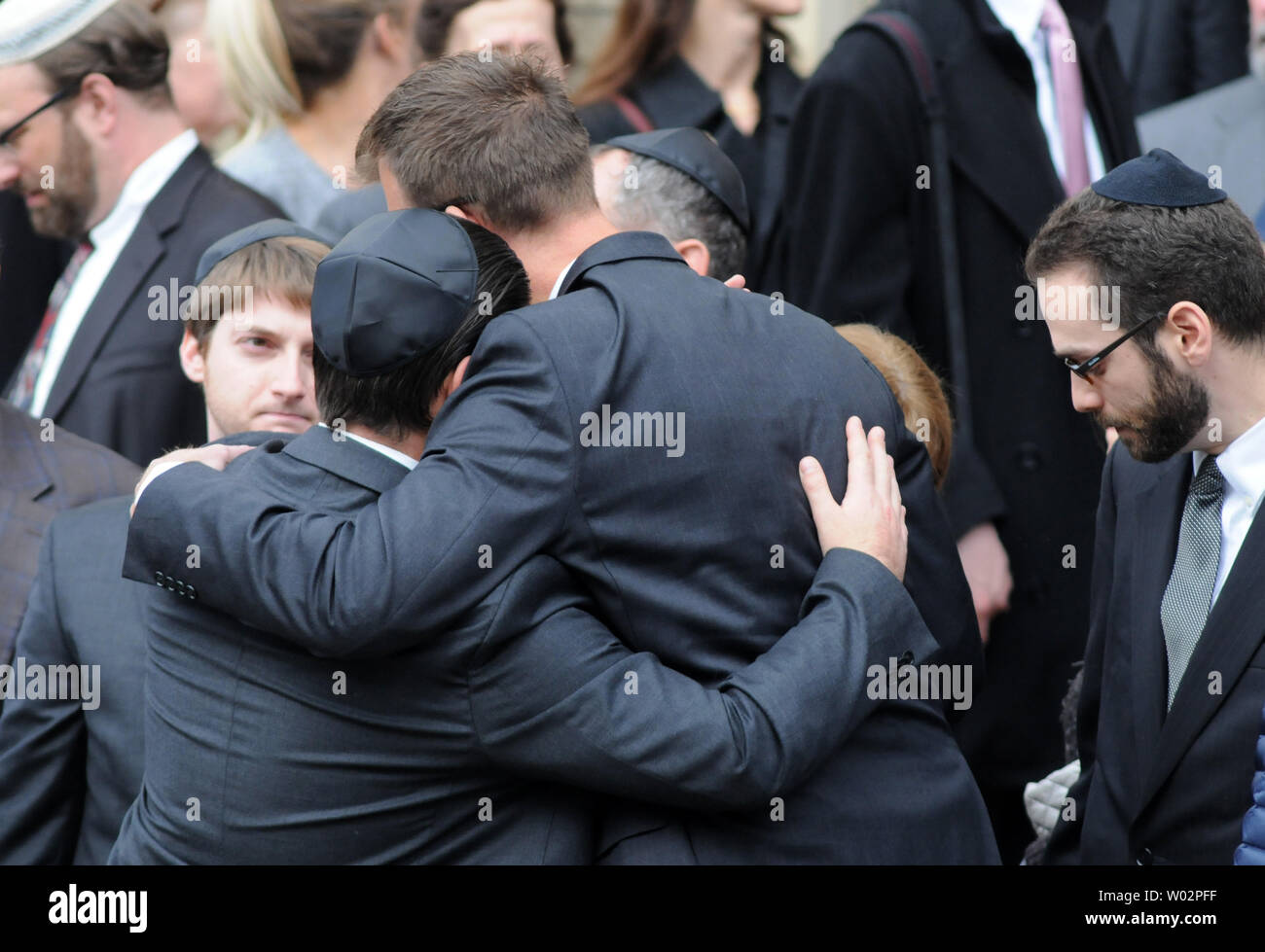 Mourners embrace  outside the Rodef Shalom Temples following the funeral services for brothers Cecil and David Rosenthal in Pittsburgh on October 30, 2018. The brothers where victims of the mass shooting where a gunman kill 11 people at the Tree of Life Synagogue.   Photo by Archie Carpenter/UPI Stock Photo