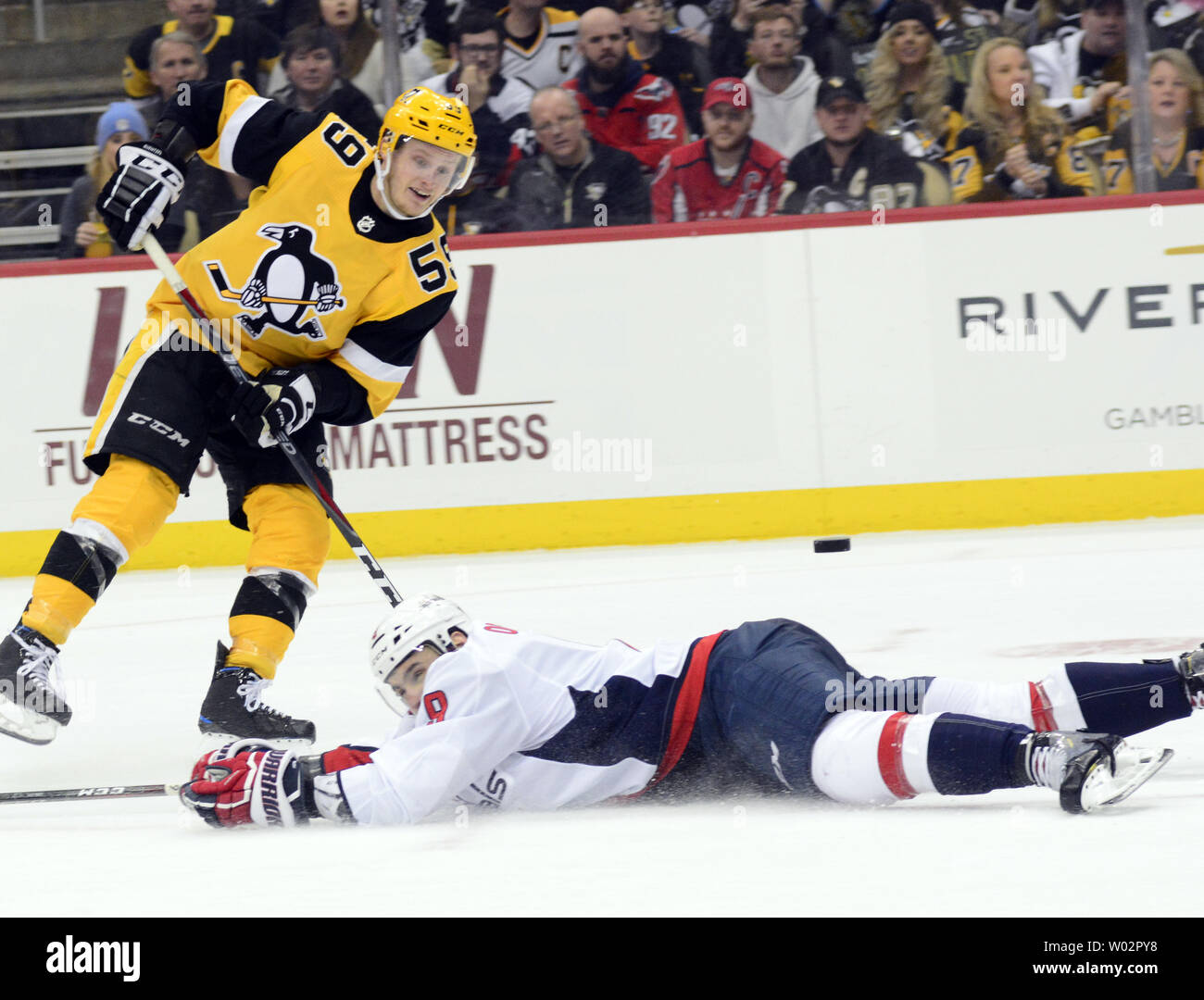 Pittsburgh Penguins left wing Jake Guentzel (59) takes a shot over the diving Washington Capitals defenseman Dmitry Orlov (9) during the third period of the Pens 5-3 win at PPG Paints Arena in Pittsburgh on March 12, 2018.   Photo by Archie Carpenter/UPI Stock Photo