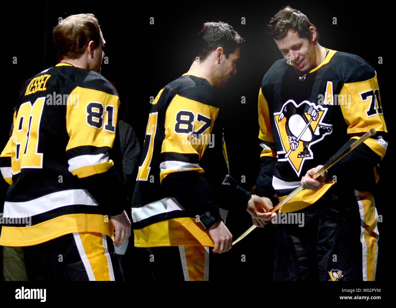 Pittsburgh Penguins center Sidney Crosby (87) presents Pittsburgh Penguins center Evgeni Malkin (71) presents the stick from his 1000 point game before the start of the St. Louis Blues 5-1 win at PPG Paints Arena in Pittsburgh on March 16, 2018.   Photo by Archie Carpenter/UPI Stock Photo