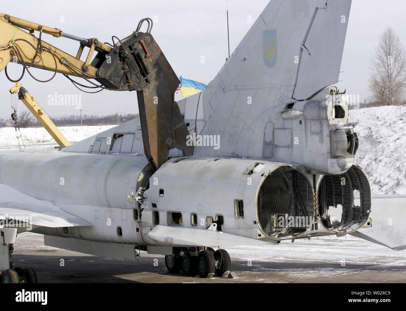 An excavator cuts the last strategic Tupolev Tu-22M3 Backfire bomber at an airbase outside of Ukrainian town Poltava, 200 miles southeast of Kiev, January 27, 2006. Ukraine inherited from the Soviet Union 60 Tu-22 bombers and 423 X-22 cruise missiles and eliminate them according to the 1993 agreement with US on the elimination of strategic nuclear weapons and nuclear non-proliferation. (UPI Photo/Sergey Starostenko) Stock Photo