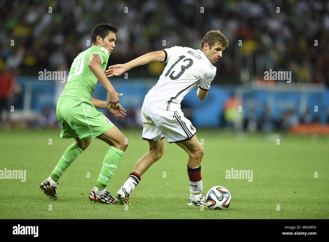Thomas Muller of Germany competes with Aissa Mandi (L) of Algeria during the 2014 FIFA World Cup Round of 16 match at the Estadio Beira-Rio in Porto Alegre, Brazil on June 30, 2014. UPI/Chris Brunskill Stock Photo