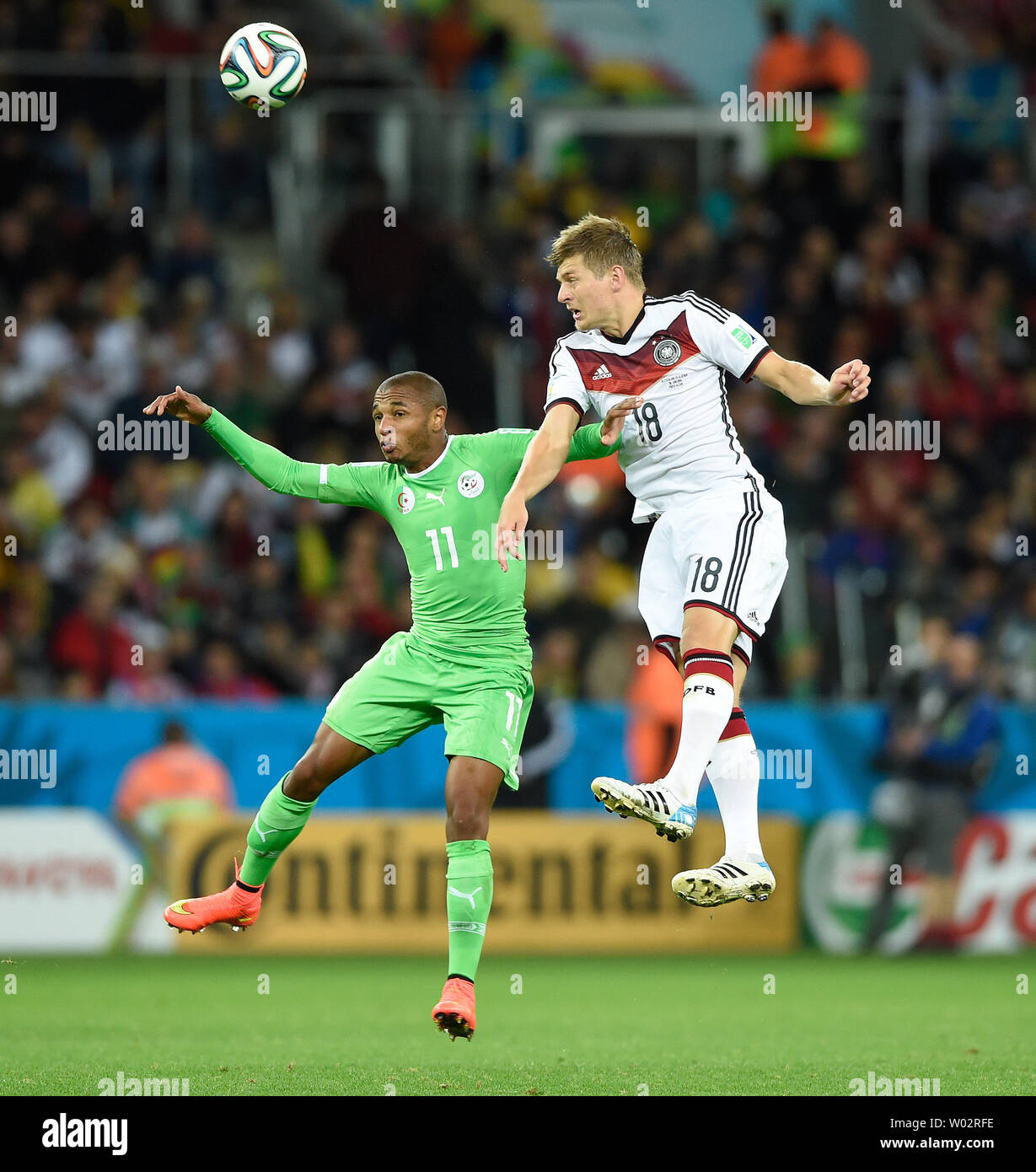 Toni Kroos of Germany jumps with Yacine Brahimi (L) of Algeria during the 2014 FIFA World Cup Round of 16 match at the Estadio Beira-Rio in Porto Alegre, Brazil on June 30, 2014. UPI/Chris Brunskill Stock Photo