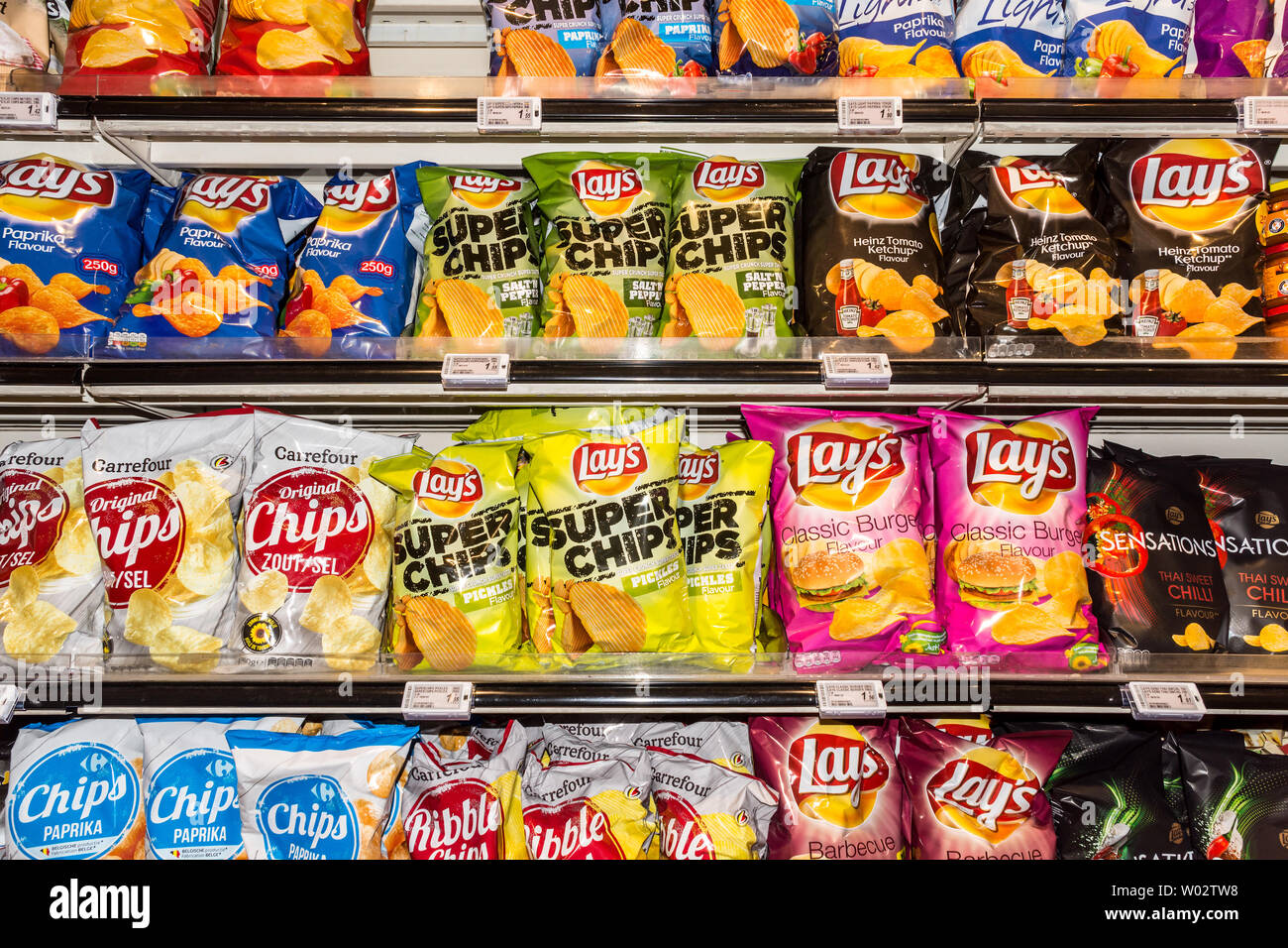 Assorted packets of 'Lays' crisps and chips on store shelves.- Belgium. Stock Photo