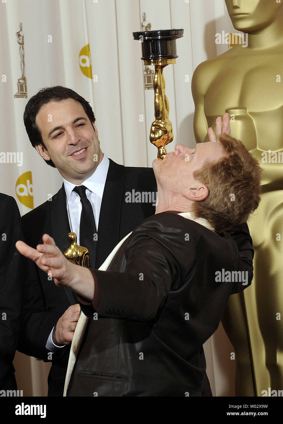 Simon Chinn watches as artist Phillippe Petit balances his Oscar for the film 'Man on Wire' on his chin backstage at the 81st Academy Awards in Hollywood on February 22, 2009.   UPI/Phil McCarten Stock Photo