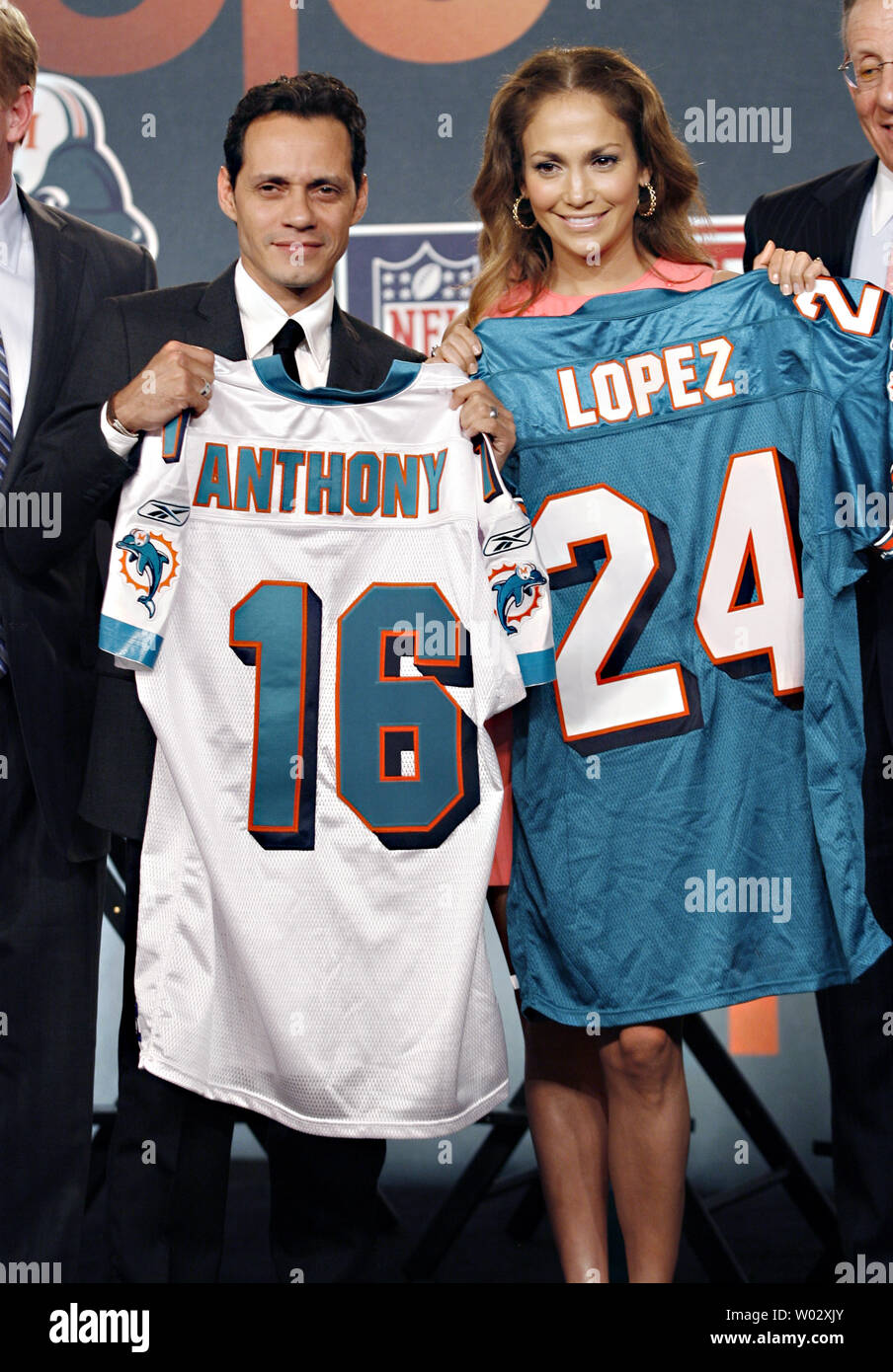 Jennifer Lopez and Marc Anthony hold up Miami Dolphins Jerseys on the stage  at the NFL, ESPN/ESPN Deportes and the Miami Dolphins press conference to  announce Marc Anthony as part owner of