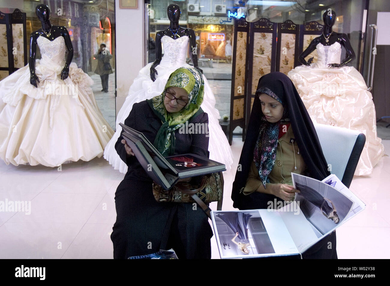 Iranian women look at an album of 