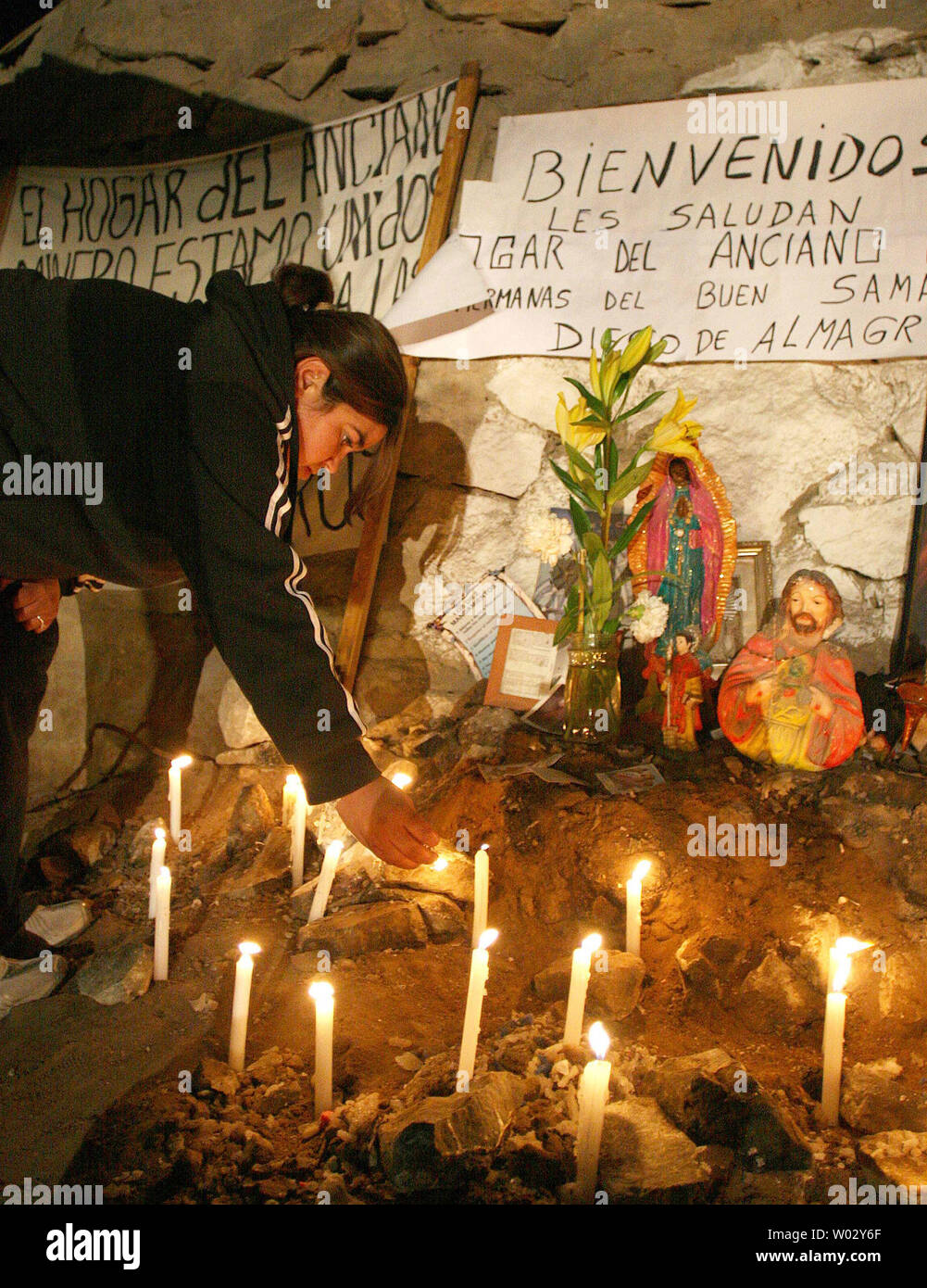 Relatives light candles near religious symbols as preparations continue to rescue the 33 trapped miners at San Jose Mine, Chile on October 12, 2010.   If all goes well, officials say the first miners will be brought up within a day via a 20-minute ride in a rescue capsule more than 2,000 feet below the surface.   The miners have been trapped for more than two months.   UPI/Sebastian Padilla Stock Photo
