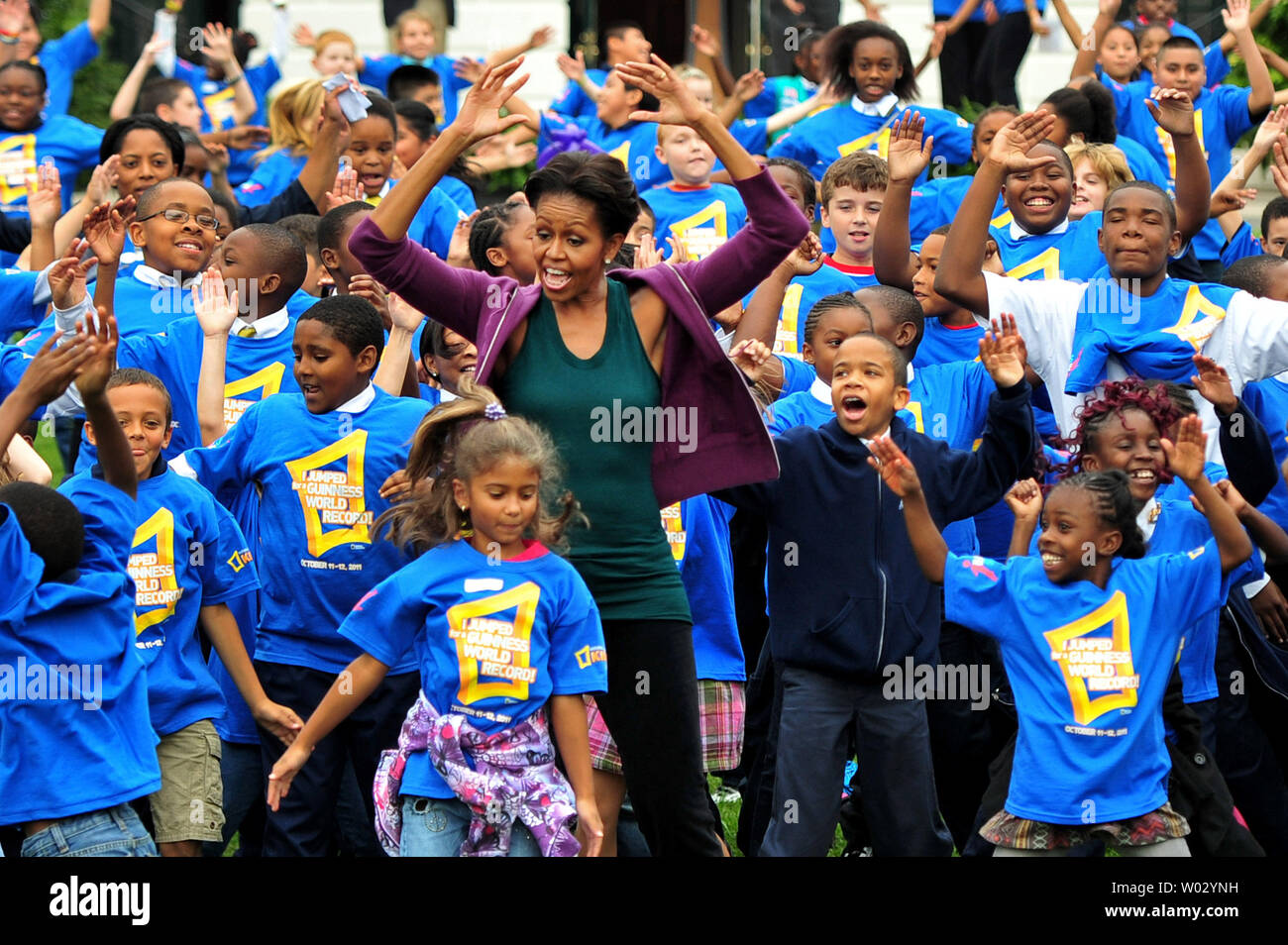 First Lady Michelle Obama and local area school children attempt to break the Guinness World Record title for the most people doing jumping jacks in a 24-hour period, at the White House in Washington on October 11, 2011.  UPI/Kevin Dietsch Stock Photo