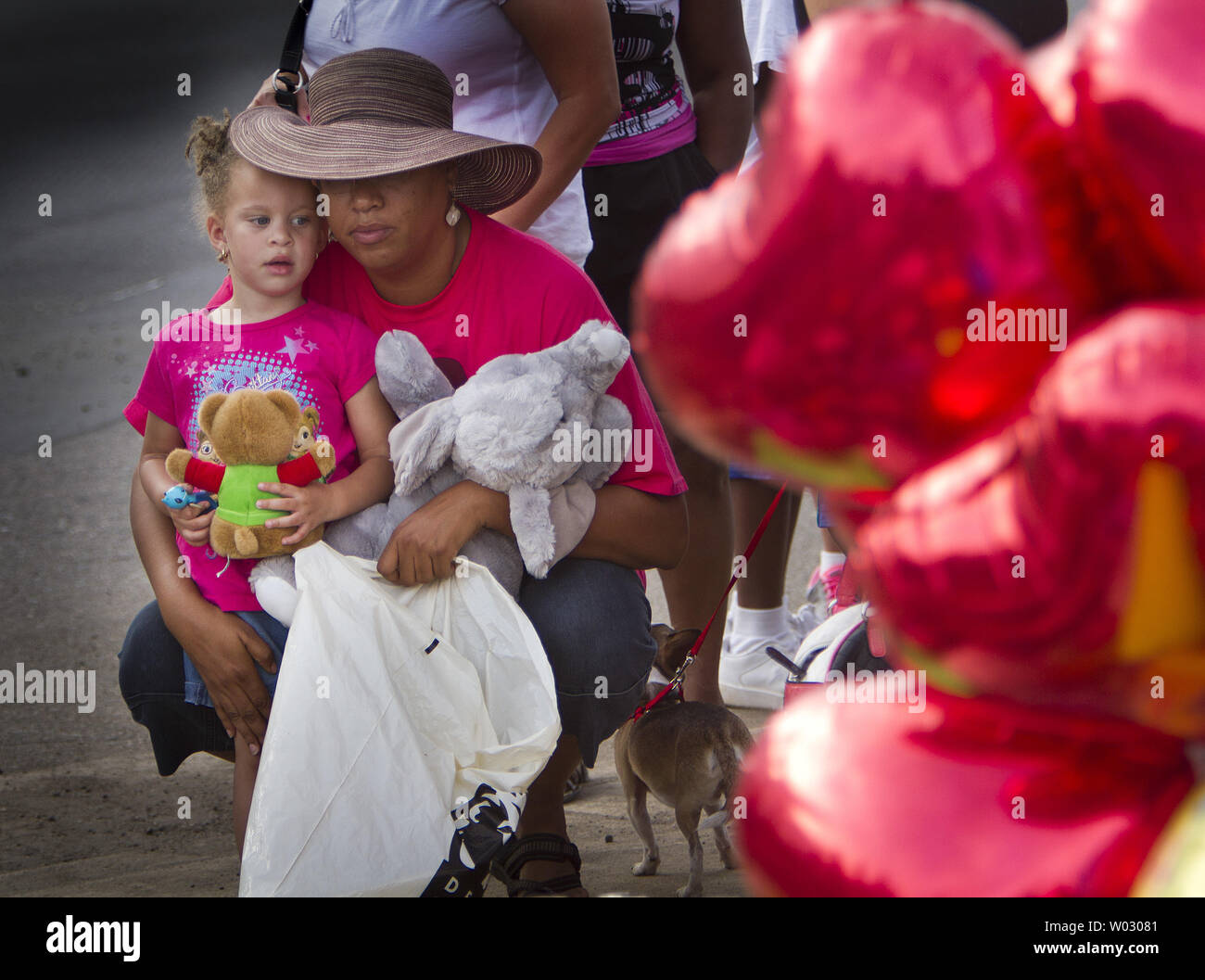 A mother and daughter bring stuffed animals to leave at a makeshift memorial for the Century 16 movie theater victims near the crime scene in Aurora, Colorado on July 21, 2012.  Twelve movie goers shot and killed with up to fifty nine more people injured at the Century 16 movie theaters at the Aurora Town Center mall.  The victims were attending a midnight premiere of the new Batman movie.  The suspect, James Holmes, allegedly threw a smoke bomb and opened fire on the moviegoers.  Holmes is in custody at the Arapahoe County Jail.    UPI/Gary C. Caskey Stock Photo